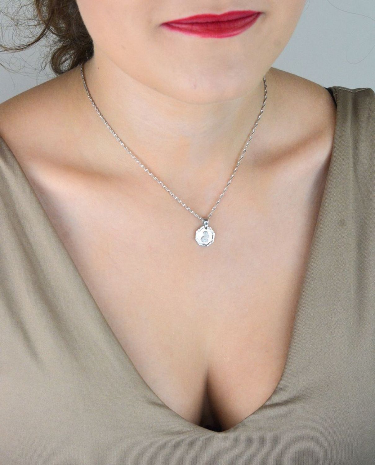 Srebrna zawieszka – medalik z Matką Boską i Dzieciątkiem, wykonana ze srebra próby 925. Klasyczny wzór o wymiarach 1,7 x 1,2 cm. Model DIA-ZAW-GMD152R-925 – symbol wiary i ochrony.1.jpg