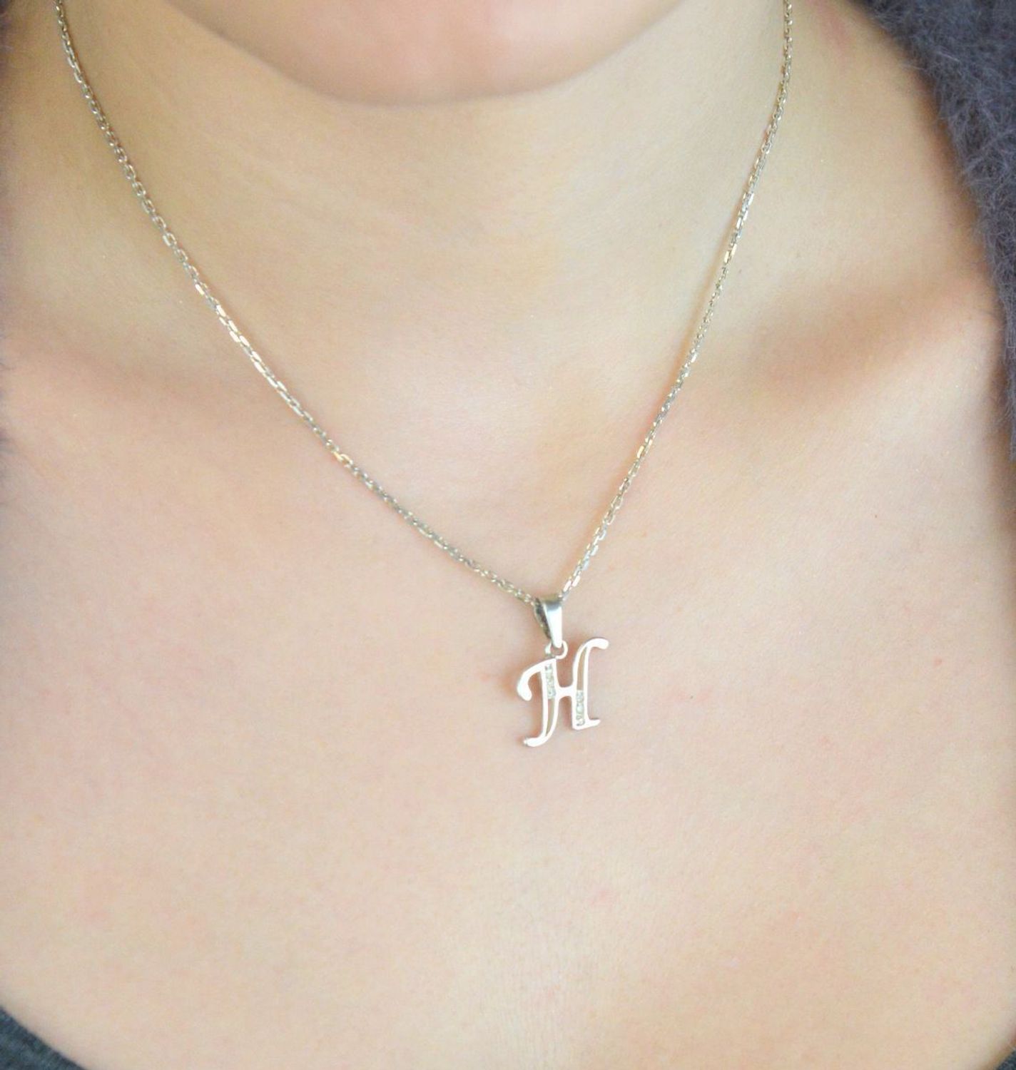 Srebrna zawieszka z literką H DIA-ZAW-LITERKA-H5-925 Subtelna i elegancka zawieszka srebrna w kształcie wielkiej, pisanej literki „H”, ozdobiona błyszczącymi cyrkoniami, które dodają jej wyjątko.jpg