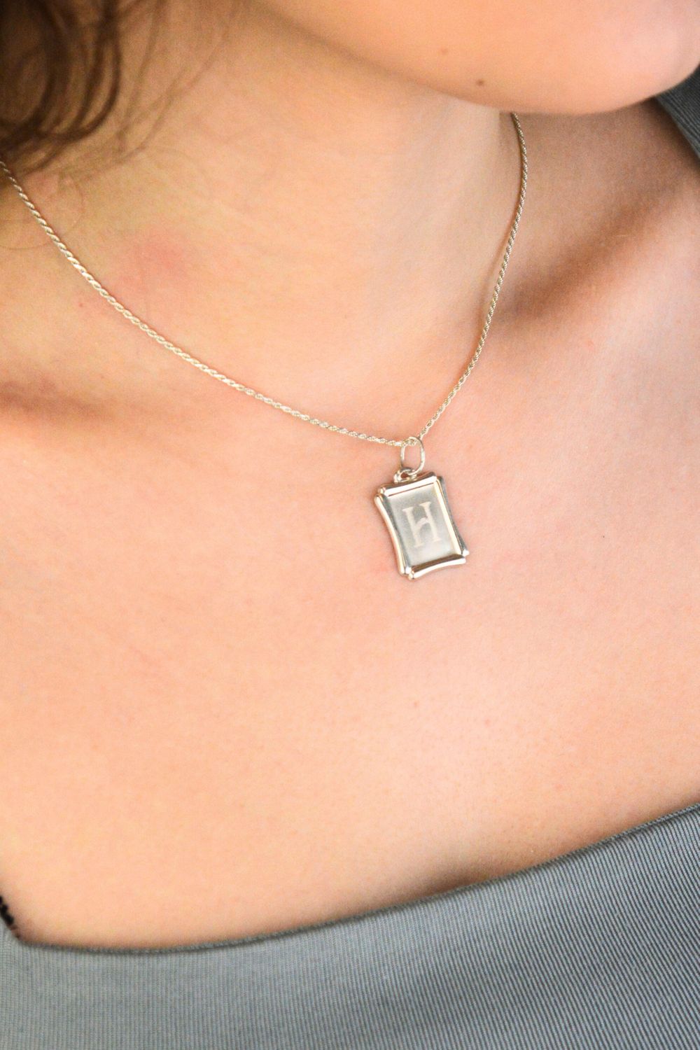 Srebrna zawieszka z literką H 925 DIA-ZAW-LITERKA-H8-925 Elegancka i minimalistyczna zawieszka srebrna w formie prostokątnej blaszki, wykonana z wysokiej jakości srebra próby 925. 1.jpg