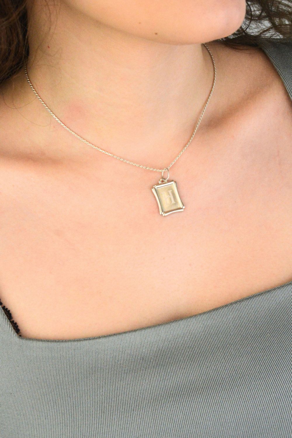 Srebrna zawieszka z literką H 925 DIA-ZAW-LITERKA-H8-925 Elegancka i minimalistyczna zawieszka srebrna w formie prostokątnej blaszki, wykonana z wysokiej jakości srebra próby 925. 1.jpg