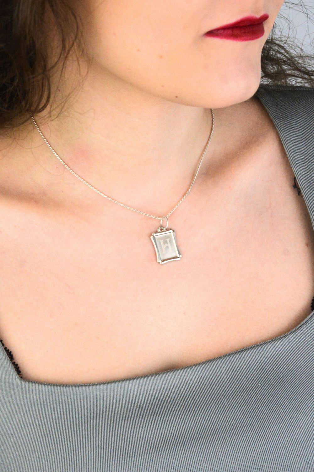 Srebrna zawieszka z literką H 925 DIA-ZAW-LITERKA-H8-925 Elegancka i minimalistyczna zawieszka srebrna w formie prostokątnej blaszki, wykonana z wysokiej jakości srebra próby 925. 1.jpg