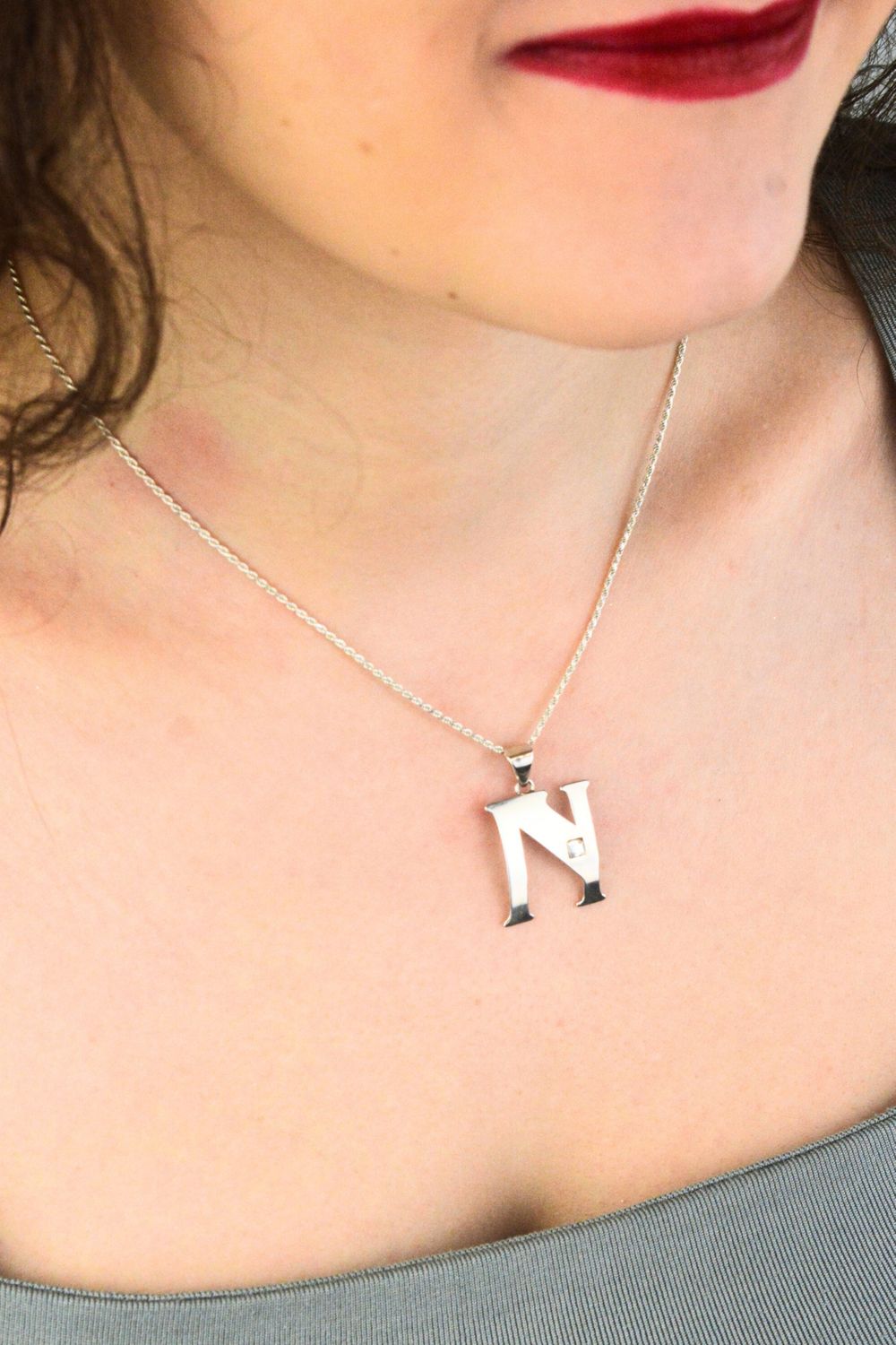 Elegancka zawieszka srebrna próby 925 w kształcie literki N, zdobiona jedną cyrkonią. Wymiary 3 × 2 cm, waga 1,30 g. Idealna do łańcuszka lub bransoletki.1.jpg