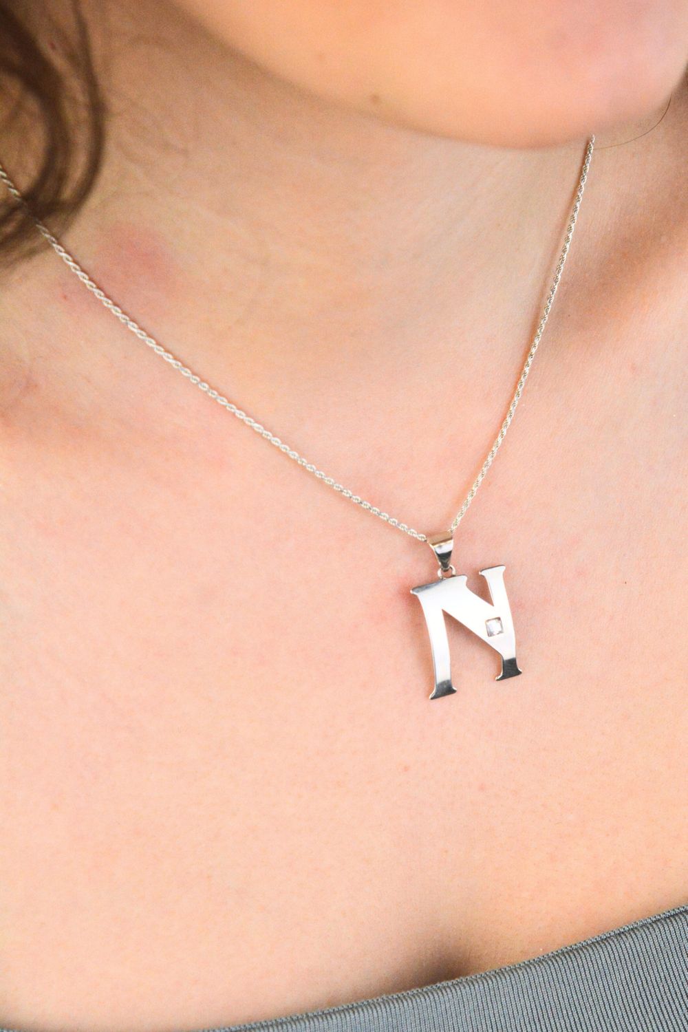 Elegancka zawieszka srebrna próby 925 w kształcie literki N, zdobiona jedną cyrkonią. Wymiary 3 × 2 cm, waga 1,30 g. Idealna do łańcuszka lub bransoletki.1.jpg