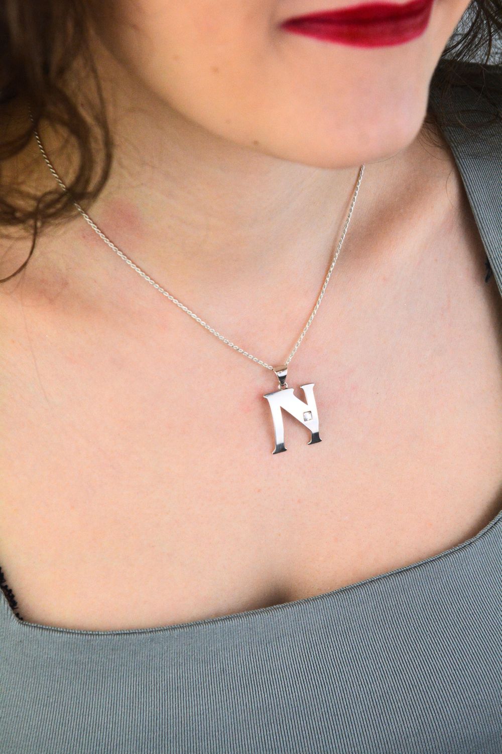 Elegancka zawieszka srebrna próby 925 w kształcie literki N, zdobiona jedną cyrkonią. Wymiary 3 × 2 cm, waga 1,30 g. Idealna do łańcuszka lub bransoletki.1.jpg