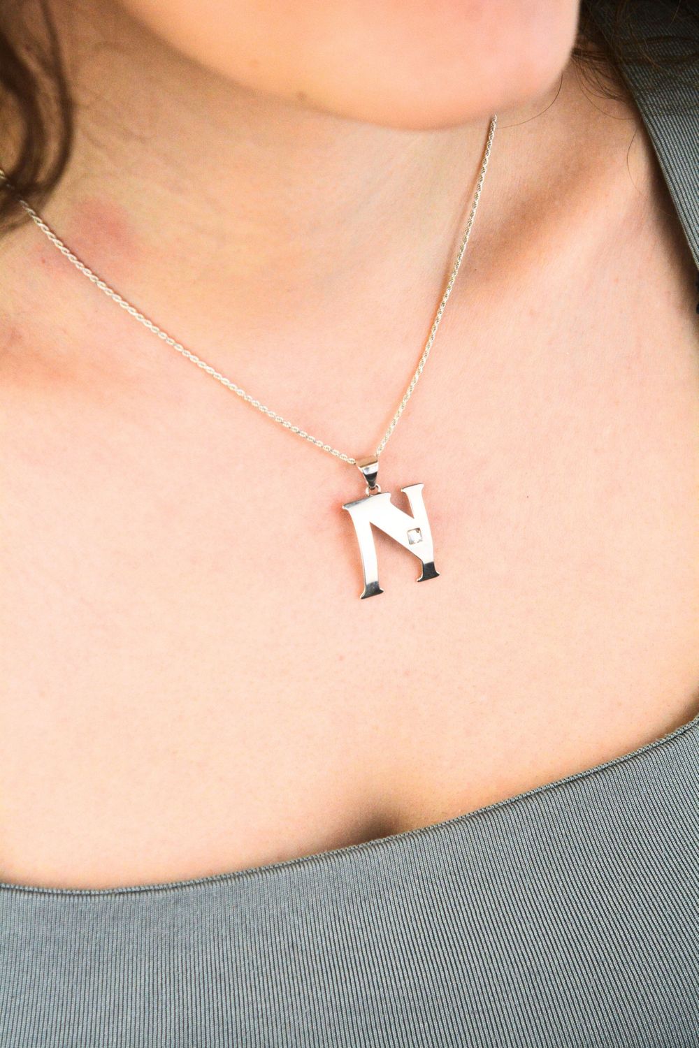 Elegancka zawieszka srebrna próby 925 w kształcie literki N, zdobiona jedną cyrkonią. Wymiary 3 × 2 cm, waga 1,30 g. Idealna do łańcuszka lub bransoletki.1.jpg