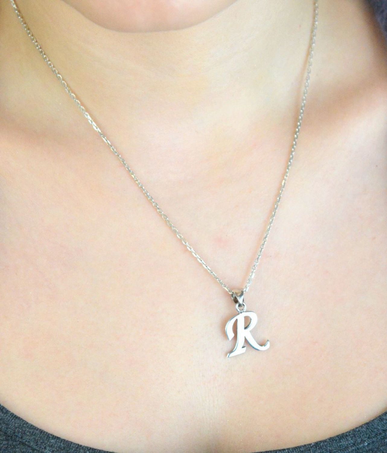 Srebrna zawieszka z literką R z gładkim wykończeniem. Wykonana ze srebra 925, elegancka i ponadczasowa – idealna na prezent lub do codziennego noszenia.1.jpg