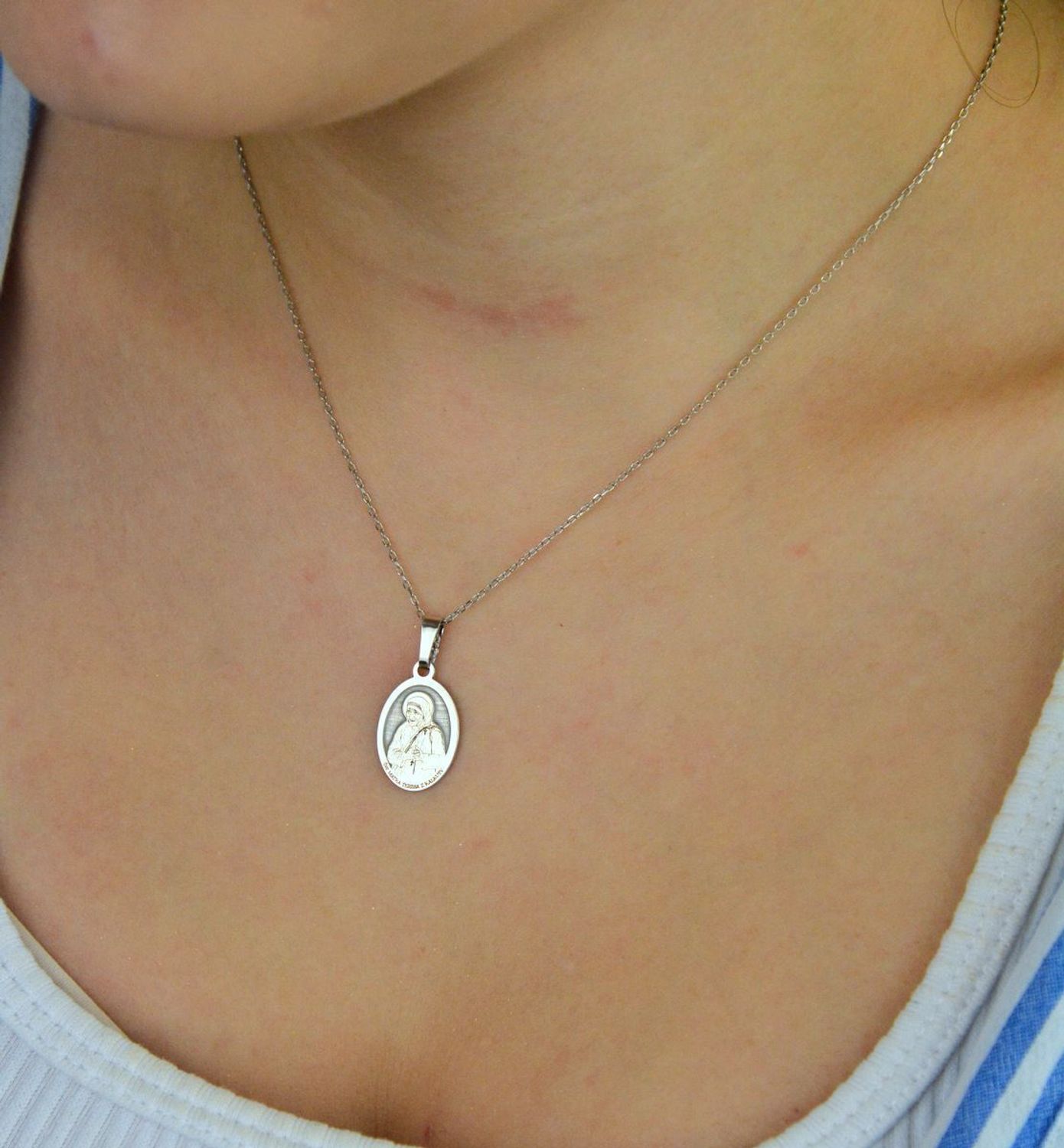 Srebrny rodowany medalik Ag 925 z wizerunkiem Św. Matki Teresy z Kalkuty. Z napisem „Wrażliwość na innych jest początkiem świętości”, wymiary 12 x 19 mm, waga 1,2–1,4 g, elegancki i symboliczny2.jpg