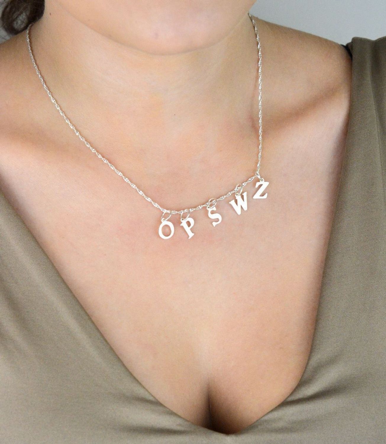 Srebrna zawieszka 925 w kształcie litery O. Wymiary 1,5x0,8 cm, waga 0,42 g. Subtelna biżuteria o spersonalizowanym charakterze – idealna na prezent.1.jpg