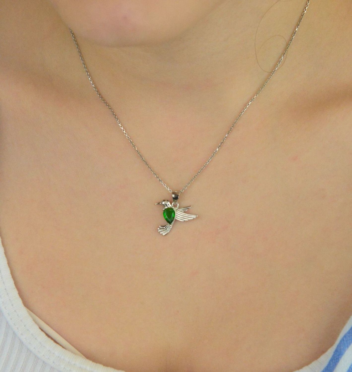 Srebrna rodowana zawieszka 925 w kształcie kolibra z cyrkonią w kolorze emerald. Wymiary 18x18 mm. Symboliczna i elegancka biżuteria idealna na prezent.1.jpg