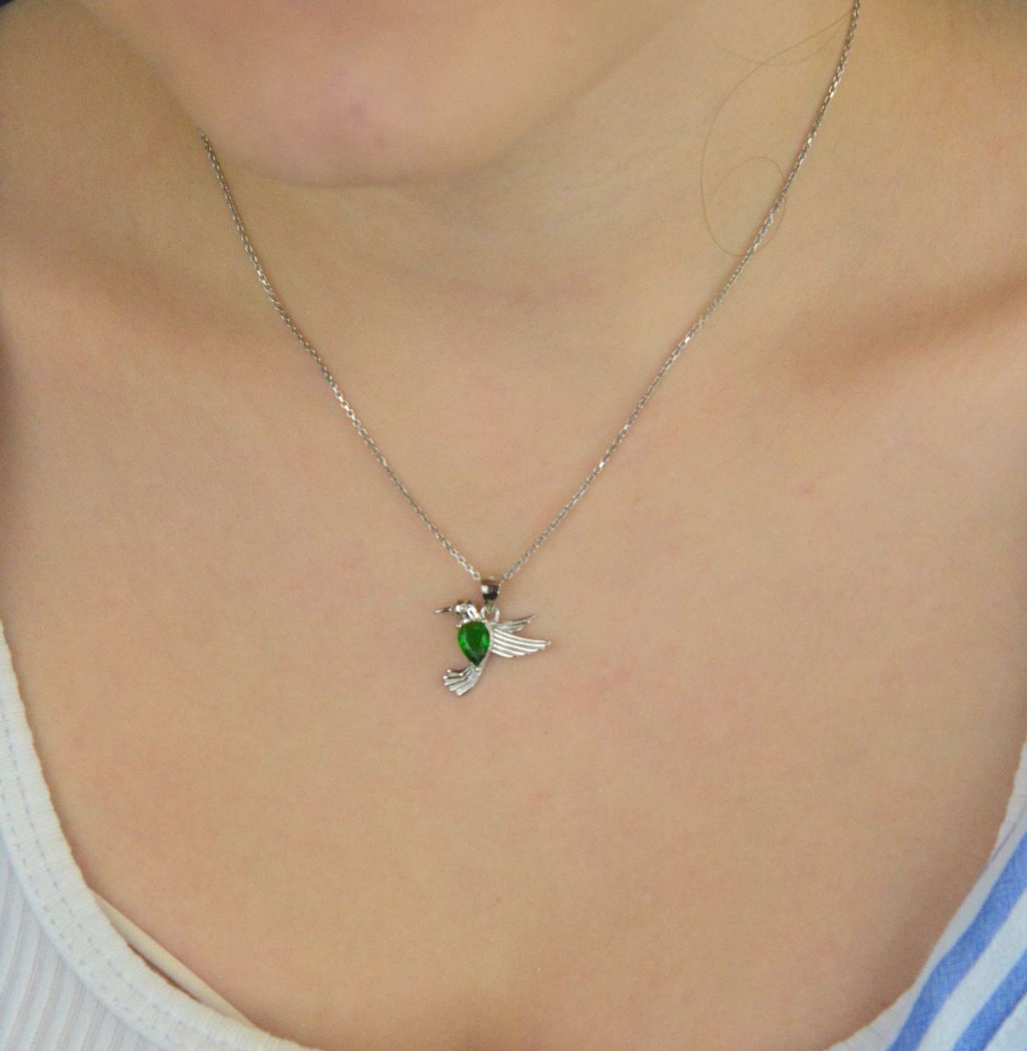 Srebrna rodowana zawieszka 925 w kształcie kolibra z cyrkonią w kolorze emerald. Wymiary 18x18 mm. Symboliczna i elegancka biżuteria idealna na prezent.1.jpg