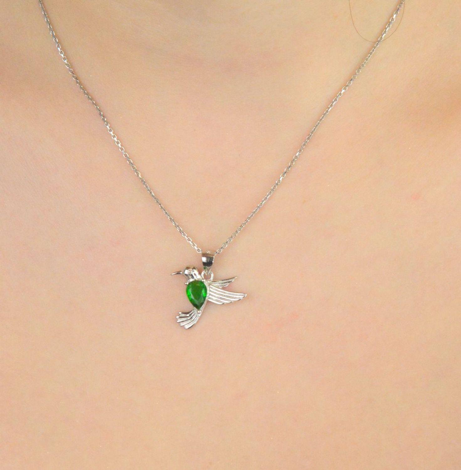 Srebrna rodowana zawieszka 925 w kształcie kolibra z cyrkonią w kolorze emerald. Wymiary 18x18 mm. Symboliczna i elegancka biżuteria idealna na prezent.1.jpg