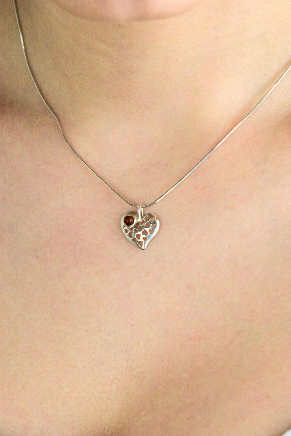 Subtelna srebrna zawieszka próby 925 w kształcie ażurowego serduszka z naturalnym bursztynem. Delikatna, lekka i idealna na prezent.1.jpg