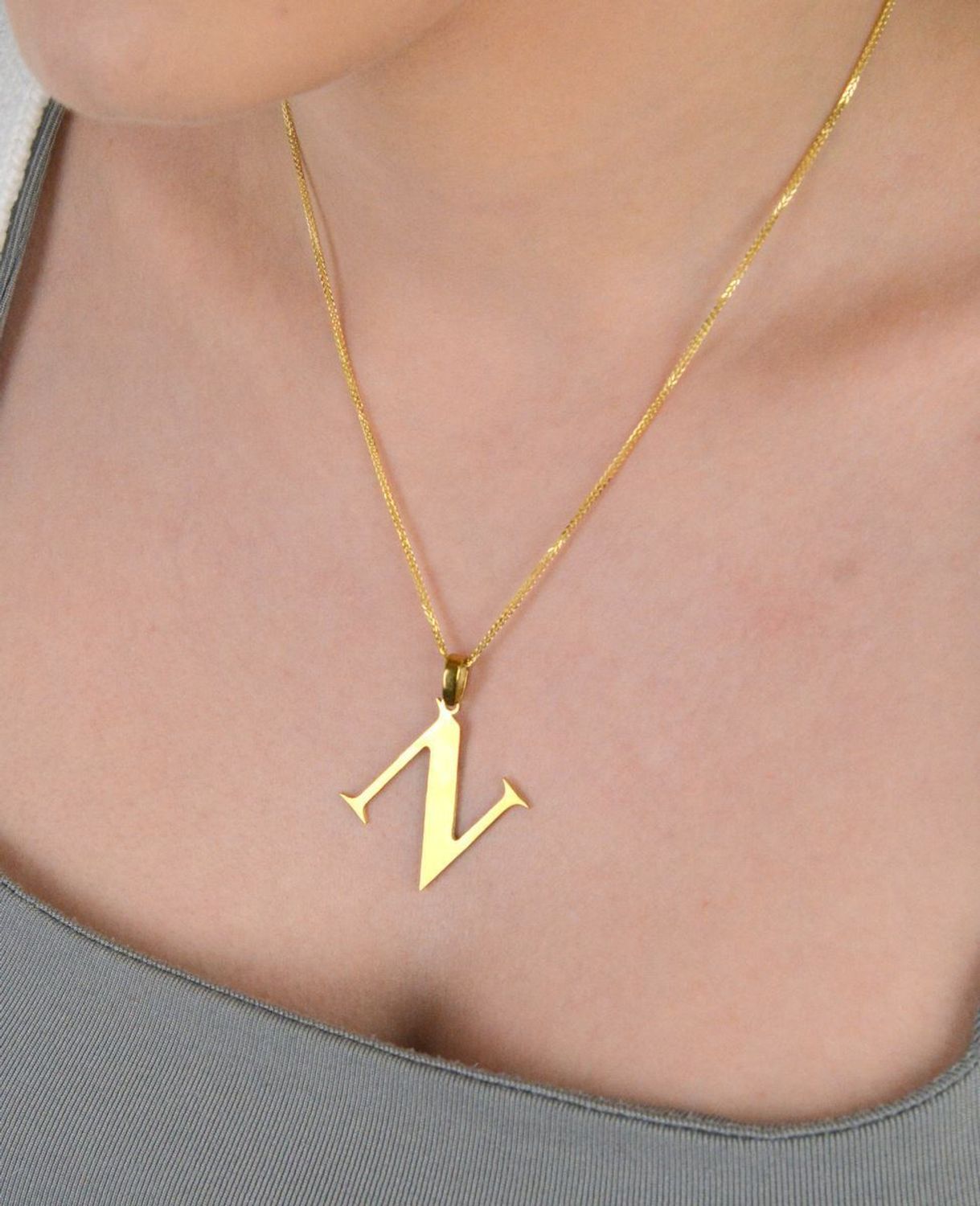 Zawieszka stalowa literka N pozłacana, DIA-ZAW-ZN10819-STAL Elegancka zawieszka w kształcie literki N, wykonana ze stali nierdzewnej i pozłacana, co zapewnia jej trwałość i wyjątkowy wygląd. 1.jpg