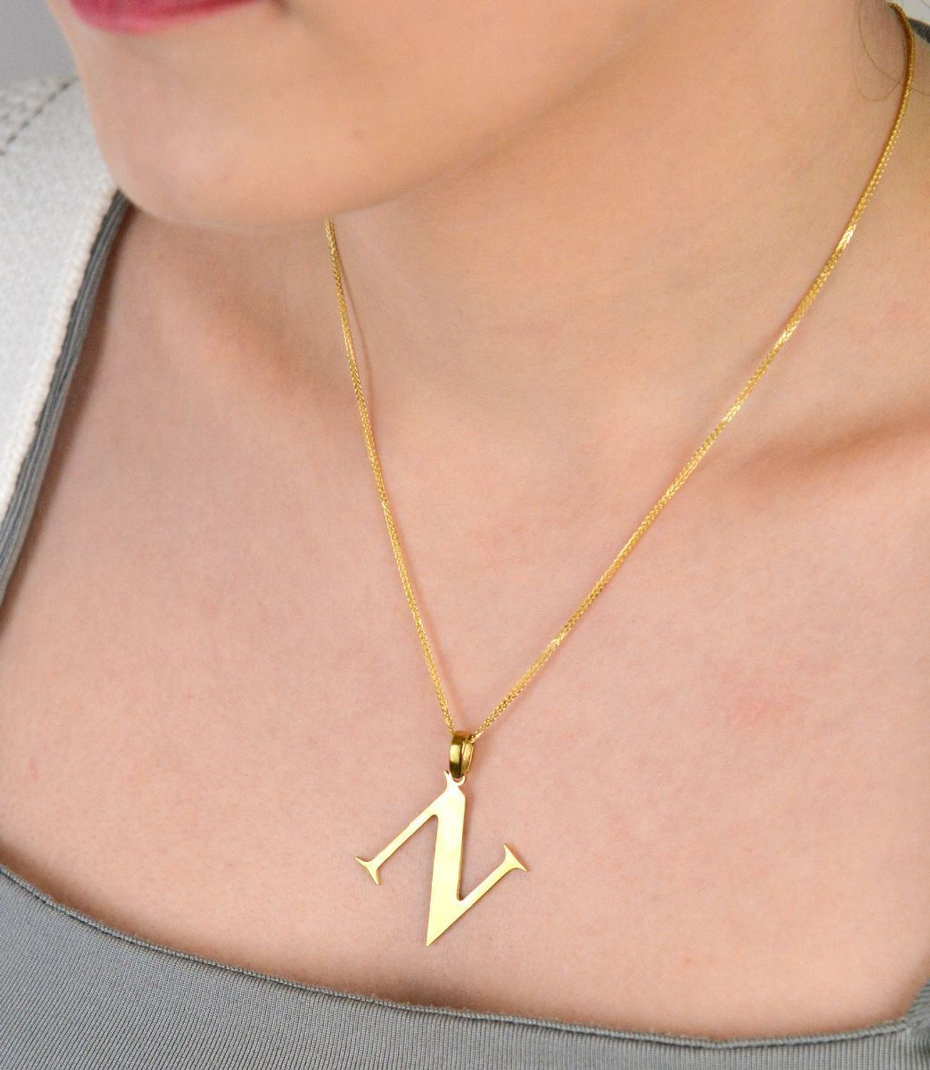 Zawieszka stalowa literka N pozłacana, DIA-ZAW-ZN10819-STAL Elegancka zawieszka w kształcie literki N, wykonana ze stali nierdzewnej i pozłacana, co zapewnia jej trwałość i wyjątkowy wygląd. 1.jpg