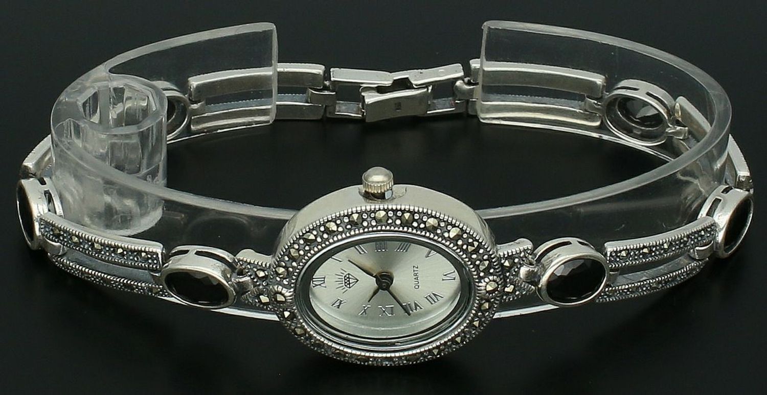 Elegancki zegarek damski ze srebra 925, waga 33,9 g. Owalna koperta 2,7 x 2,3 cm, bransoletka 21 cm x 7 mm, zdobiony markazytami i czarną cyrkonią. Grawer gratis – idealny na prezent.1.jpg