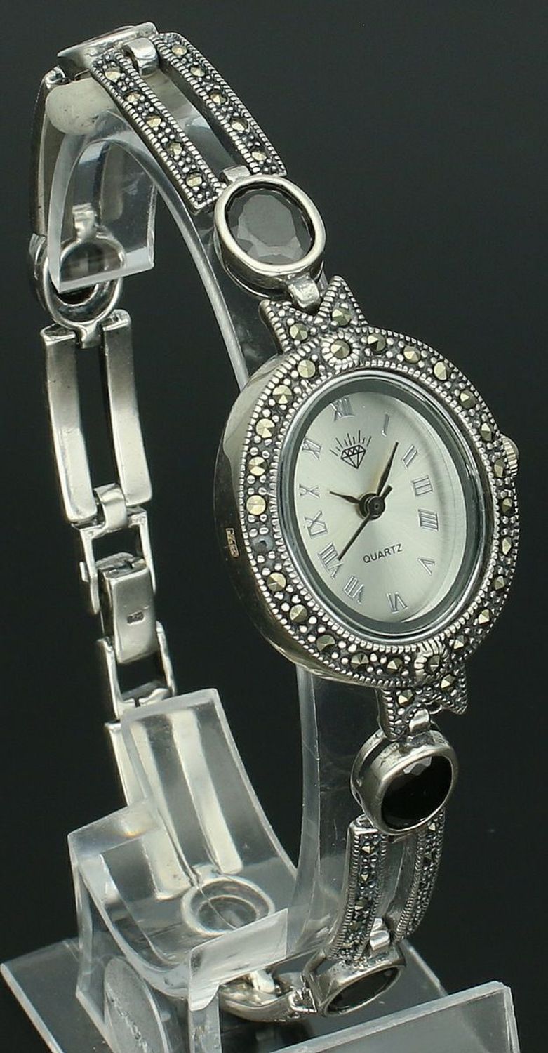 Elegancki zegarek damski ze srebra 925, waga 33,9 g. Owalna koperta 2,7 x 2,3 cm, bransoletka 21 cm x 7 mm, zdobiony markazytami i czarną cyrkonią. Grawer gratis – idealny na prezent.1.jpg