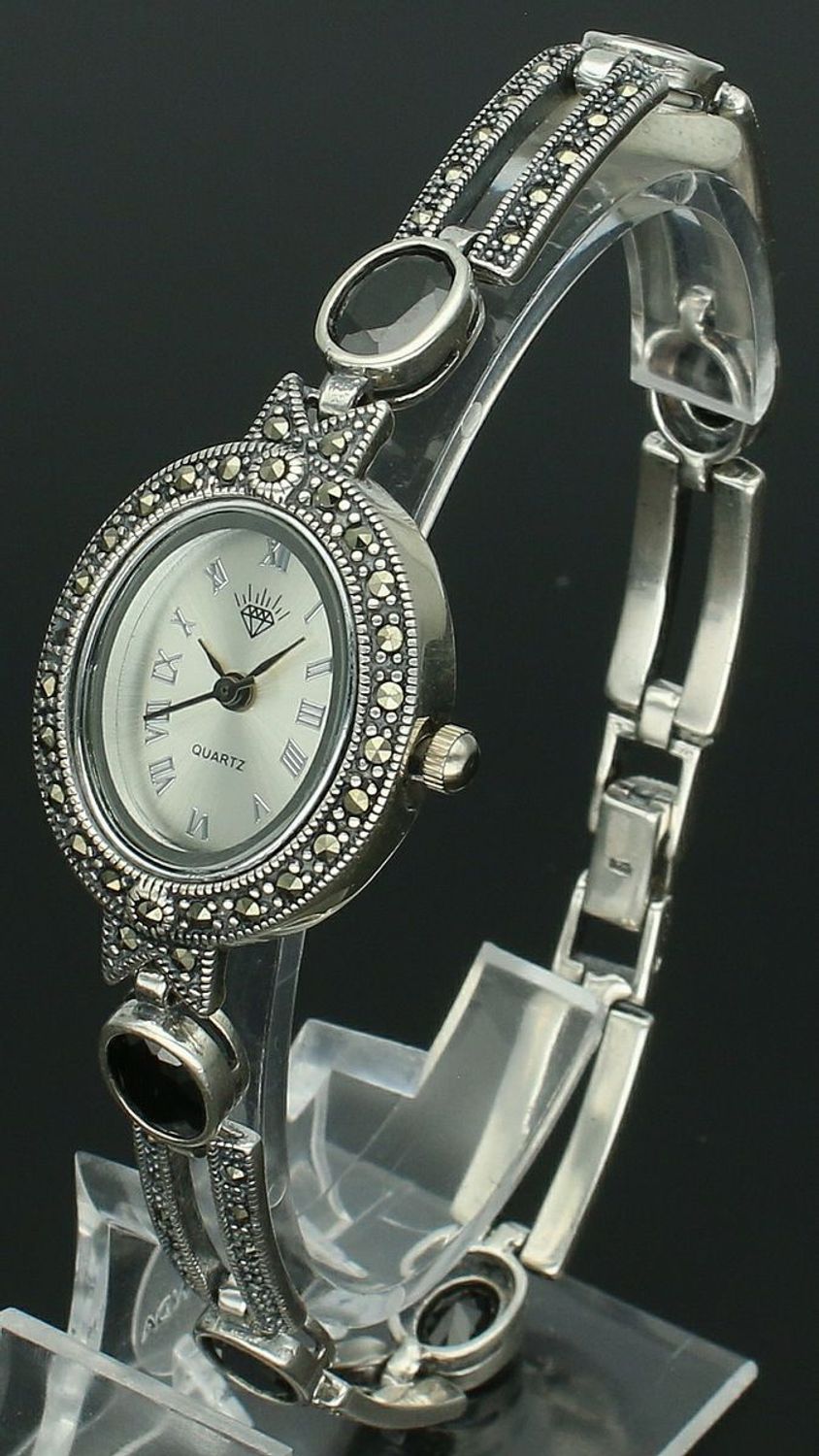 Elegancki zegarek damski ze srebra 925, waga 33,9 g. Owalna koperta 2,7 x 2,3 cm, bransoletka 21 cm x 7 mm, zdobiony markazytami i czarną cyrkonią. Grawer gratis – idealny na prezent.1.jpg