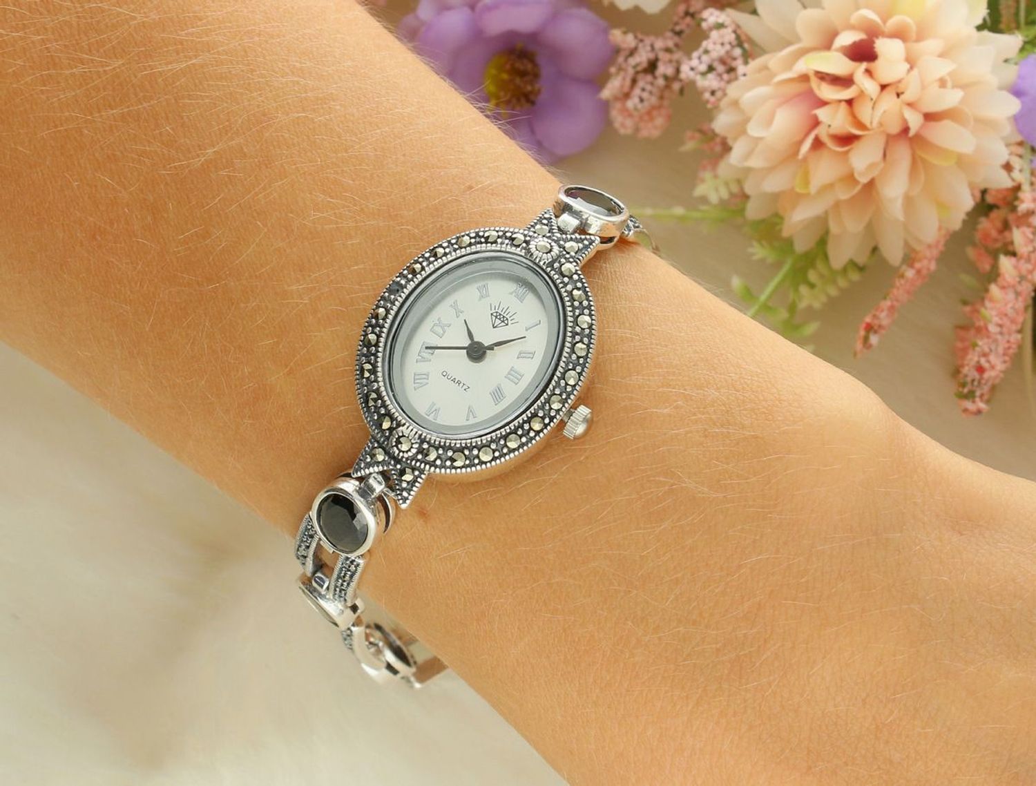 Elegancki zegarek damski ze srebra 925, waga 33,9 g. Owalna koperta 2,7 x 2,3 cm, bransoletka 21 cm x 7 mm, zdobiony markazytami i czarną cyrkonią. Grawer gratis – idealny na prezent.1.jpg