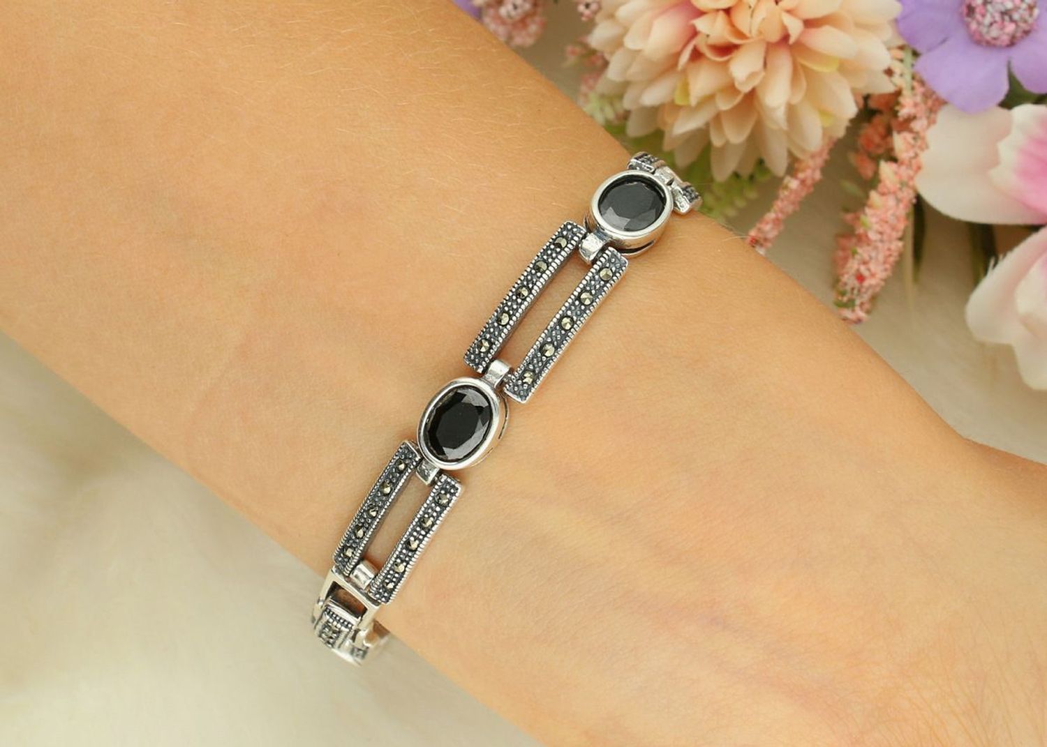 Elegancki zegarek damski ze srebra 925, waga 33,9 g. Owalna koperta 2,7 x 2,3 cm, bransoletka 21 cm x 7 mm, zdobiony markazytami i czarną cyrkonią. Grawer gratis – idealny na prezent.1.jpg