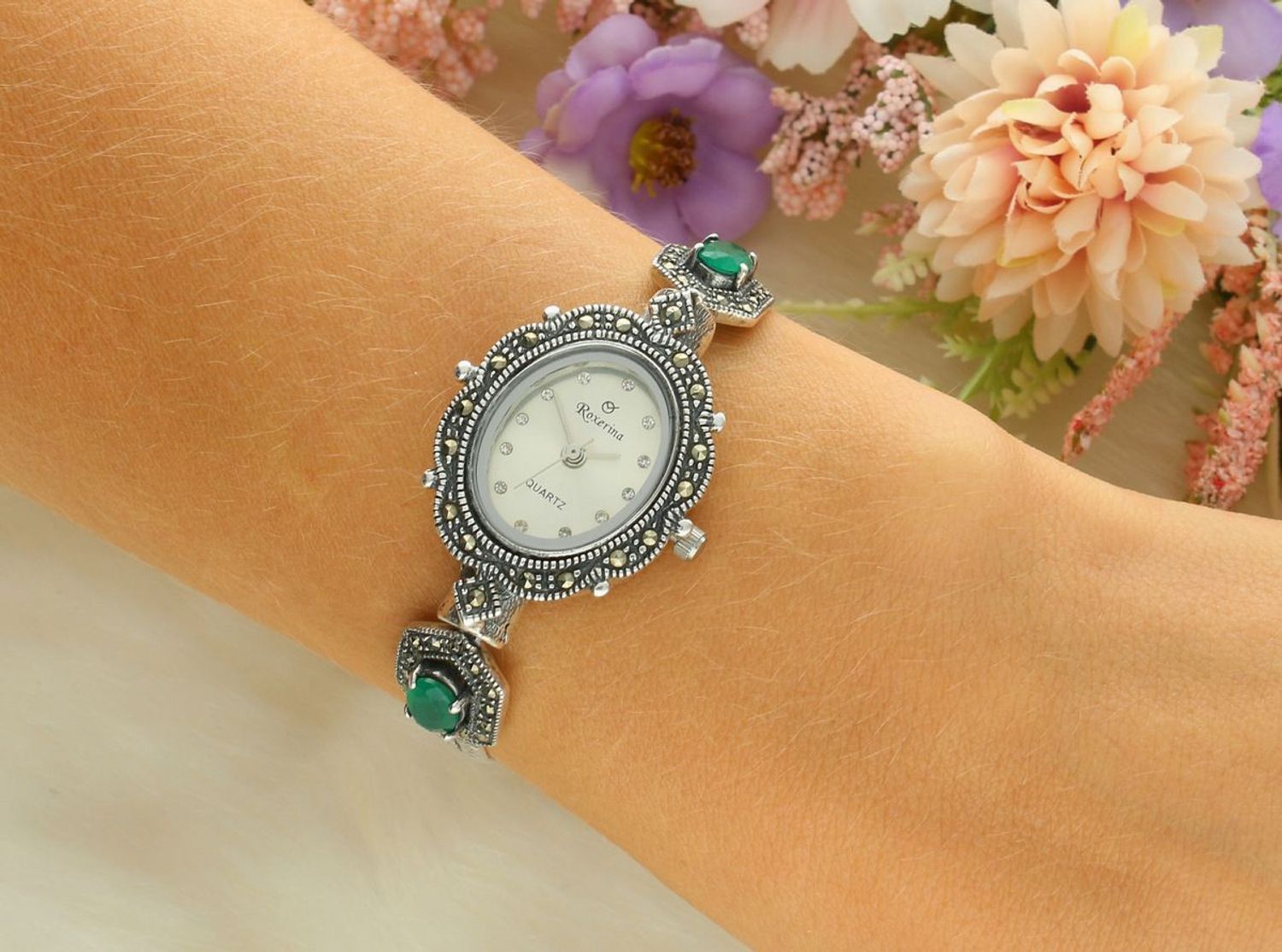 Elegancki zegarek damski ze srebra 925, waga 24 g. Owalna koperta 2,2 x 2,5 cm, bransoletka 17+3 cm, zdobiony markazytami i szmaragdami. Grawer gratis – idealny na prezent.1.jpg