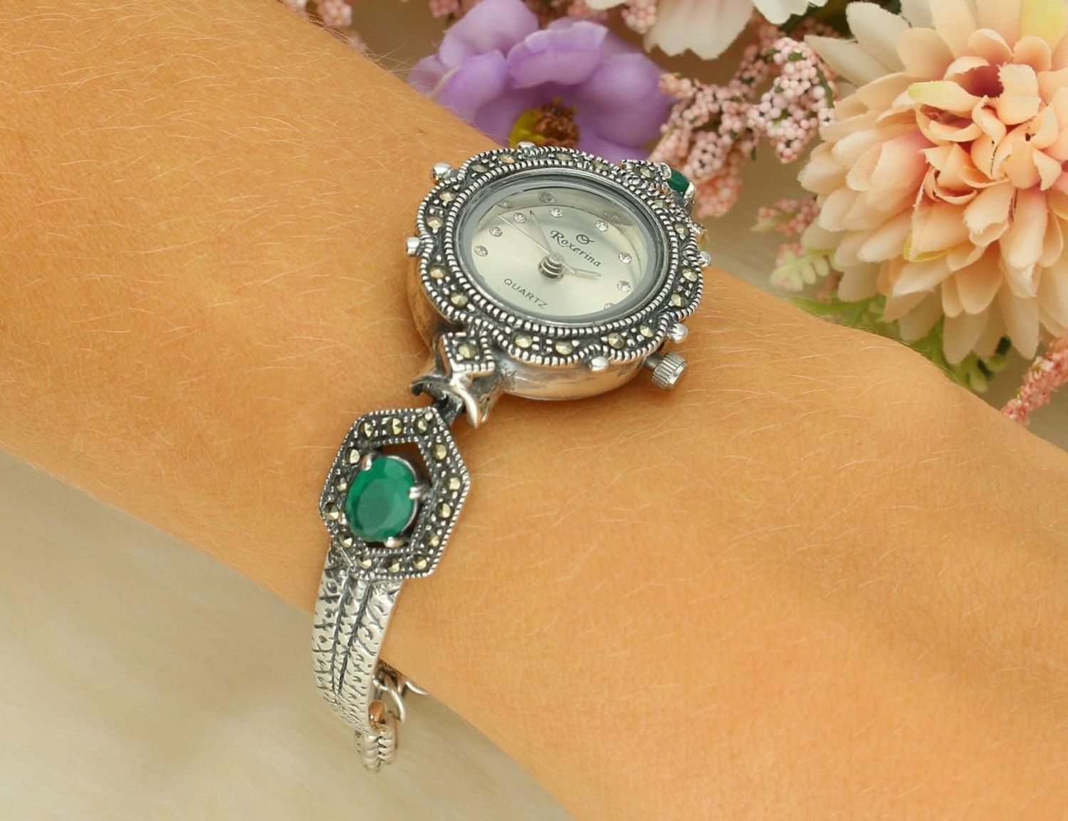 Elegancki zegarek damski ze srebra 925, waga 24 g. Owalna koperta 2,2 x 2,5 cm, bransoletka 17+3 cm, zdobiony markazytami i szmaragdami. Grawer gratis – idealny na prezent.1.jpg