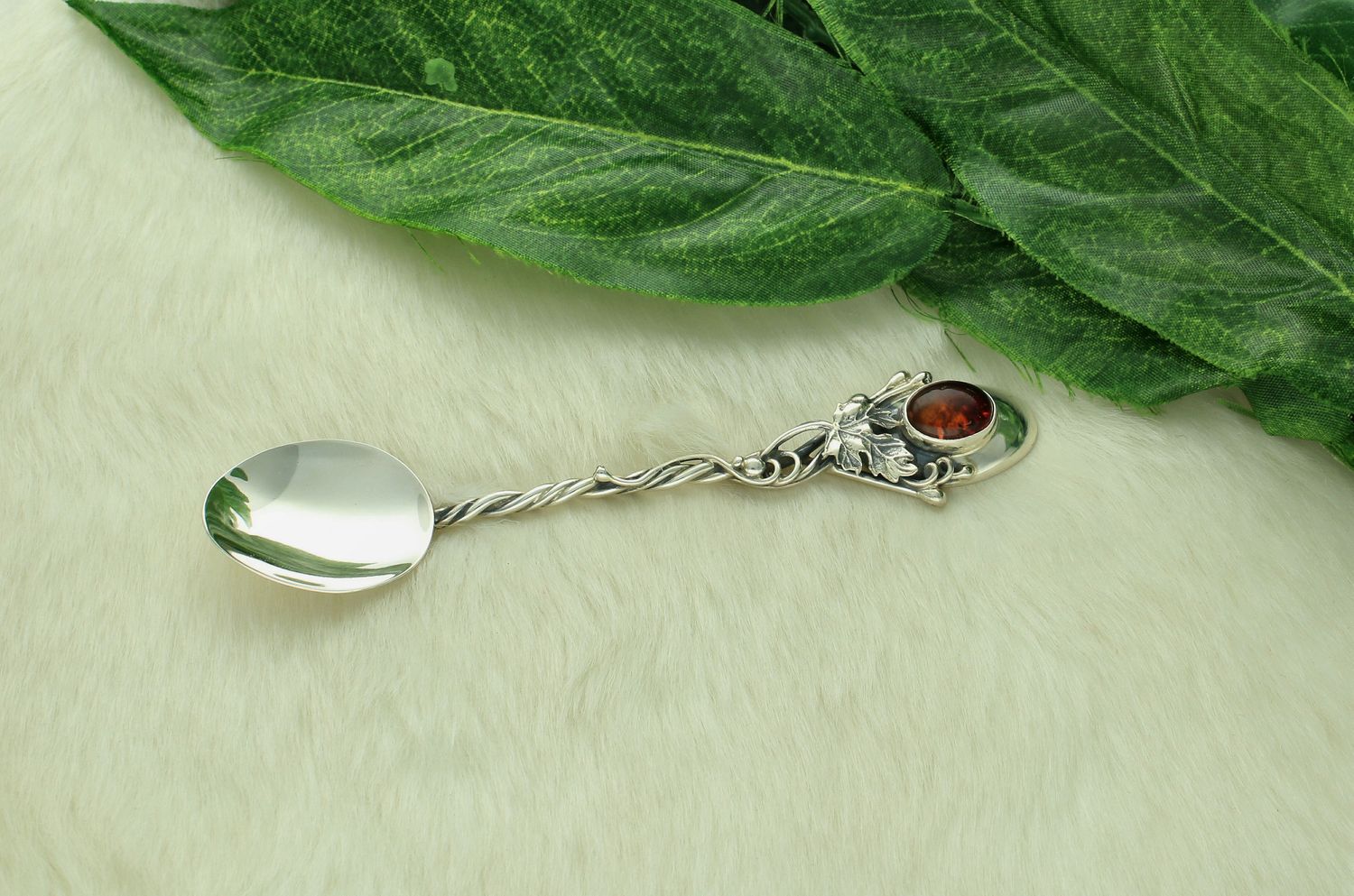 Srebrna łyżeczka do cukru z bursztynem bałtyckim i srebrnym liściem DIA-ŁYŻ-12838-925. Srebrna łyżeczka do cukru o ponadczasowym wykończeniu ozdobiona malachitem. 1.jpg