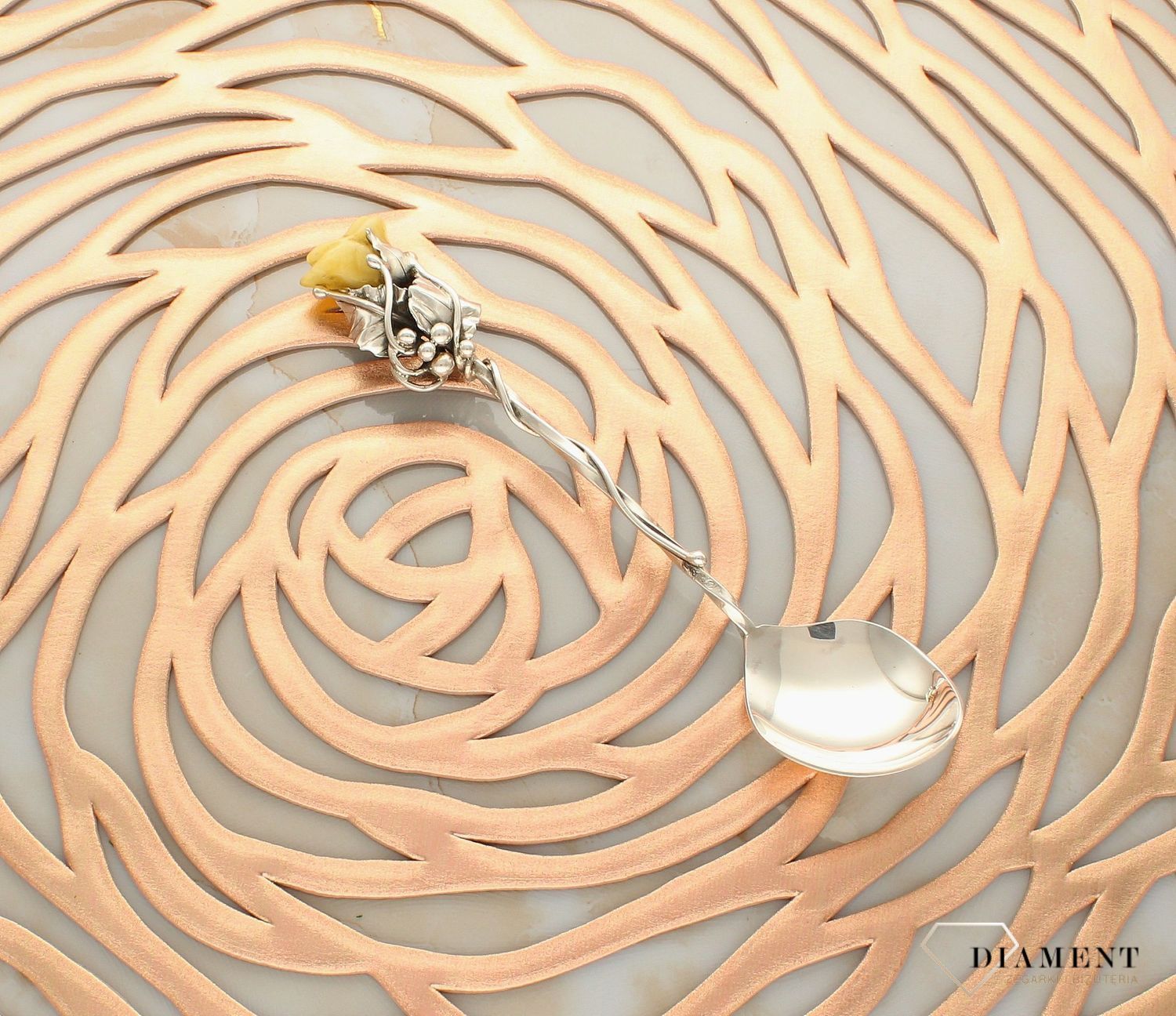 Srebrna łyżeczka z mlecznym bursztynem w kształcie róży DIA-ŁYŻ-7049-925. Srebrna łyżeczka o ponadczasowym wykończeniu ozdobiona bursztynem. Łyżeczka umieszczana jest w ozdobnym opakowaniu, chroniący przed uszkodzeniami i zab (1).jpg