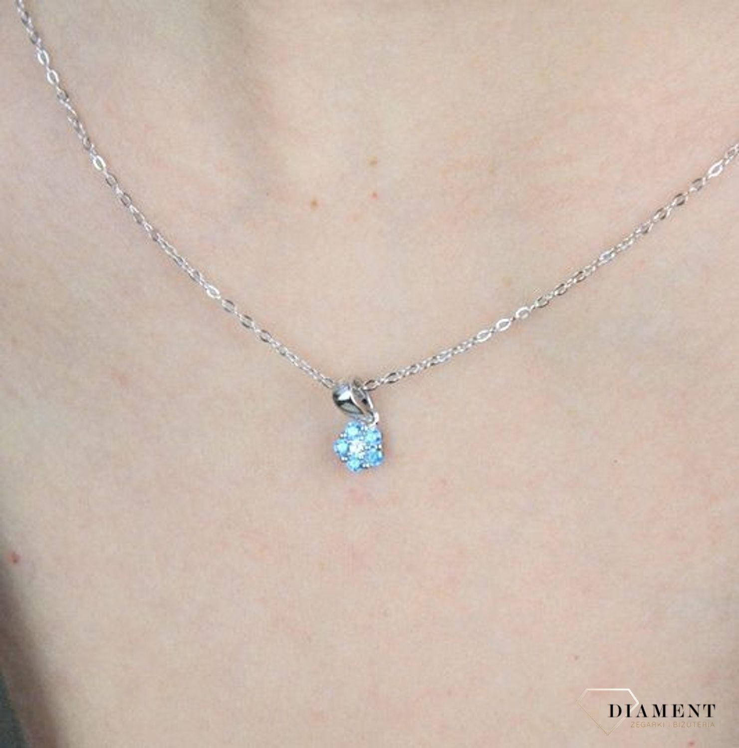 Naszyjnik srebrny kwiatek z niebieską cyrkonią JMAD0037AN38. Doskonały na prezent dla wielbicieli przyrody. Ta urokliwa biżuteria spodoba się szczególnie dziewczynkom i nastolatkom. Błękit cyrkonii przepięknie współ.jpg