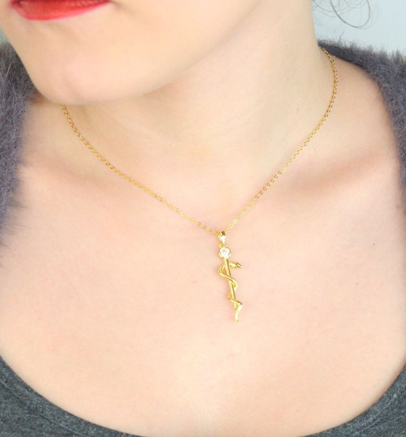 Naszyjnik srebrny JMAN0298GN z zawieszką Laska Eskulapa i białą cyrkonią. Wykonany ze srebra próby 925, długość 42+3 cm, waga 4,15 g. Idealny prezent dla lekarza, farmaceuty lub 1.jpg