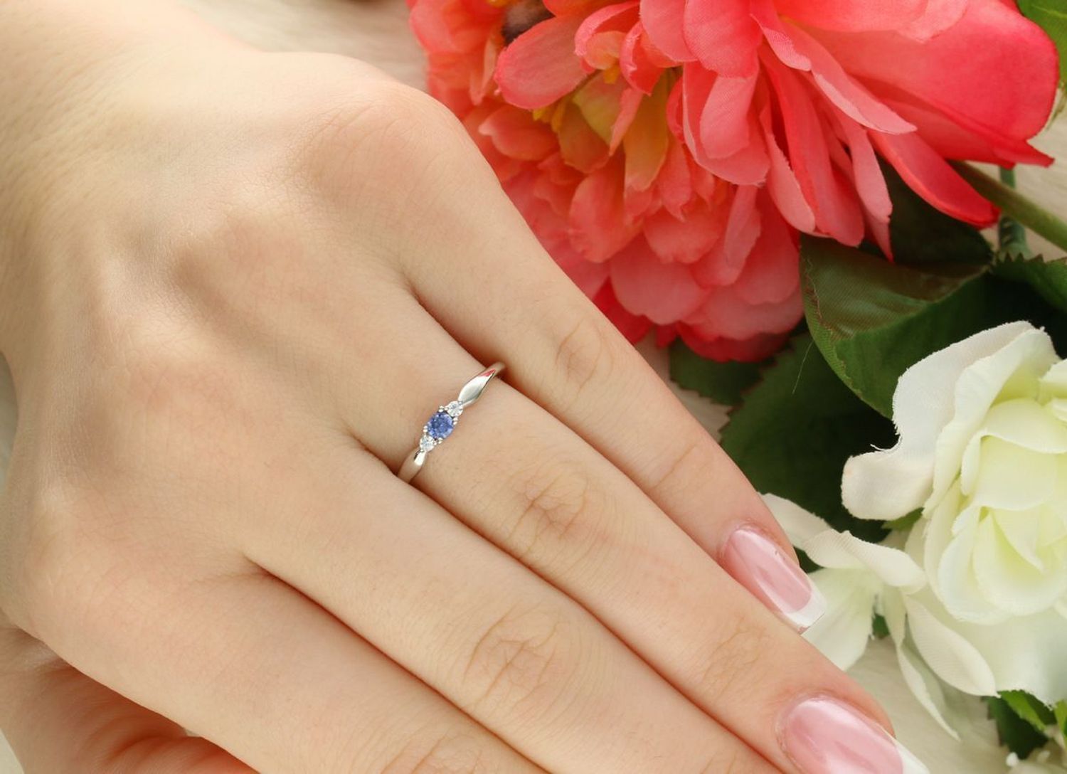 Subtelny srebrny pierścionek JMAS0285BR z niebieską i białą cyrkonią. Wykonany ze srebra próby 925, szerokość ozdobnego elementu 7×2 mm.1.jpg