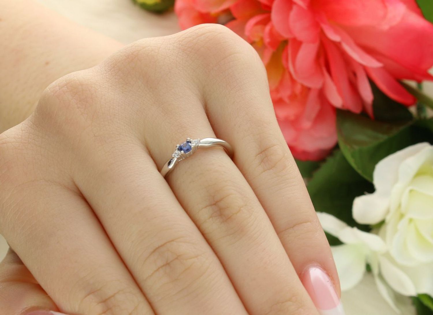 Subtelny srebrny pierścionek JMAS0285BR z niebieską i białą cyrkonią. Wykonany ze srebra próby 925, szerokość ozdobnego elementu 7×2 mm.1.jpg