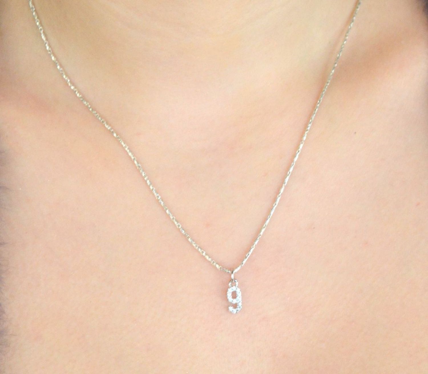 Elegancki wisiorek srebrny MINET JMAS9019SP00 w kształcie cyfry „9”, ozdobiony białymi cyrkoniami. Wykonany ze srebra próby 925, rodowany, wymiary 4x13 mm, waga 0,45 g. Idealny dodatek 1.jpg