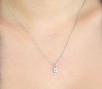 Elegancki wisiorek srebrny MINET JMAS9019SP00 w kształcie cyfry „9”, ozdobiony białymi cyrkoniami. Wykonany ze srebra próby 925, rodowany, wymiary 4x13 mm, waga 0,45 g. Idealny dodatek do codziennych i eleganckich stylizacj.JPG