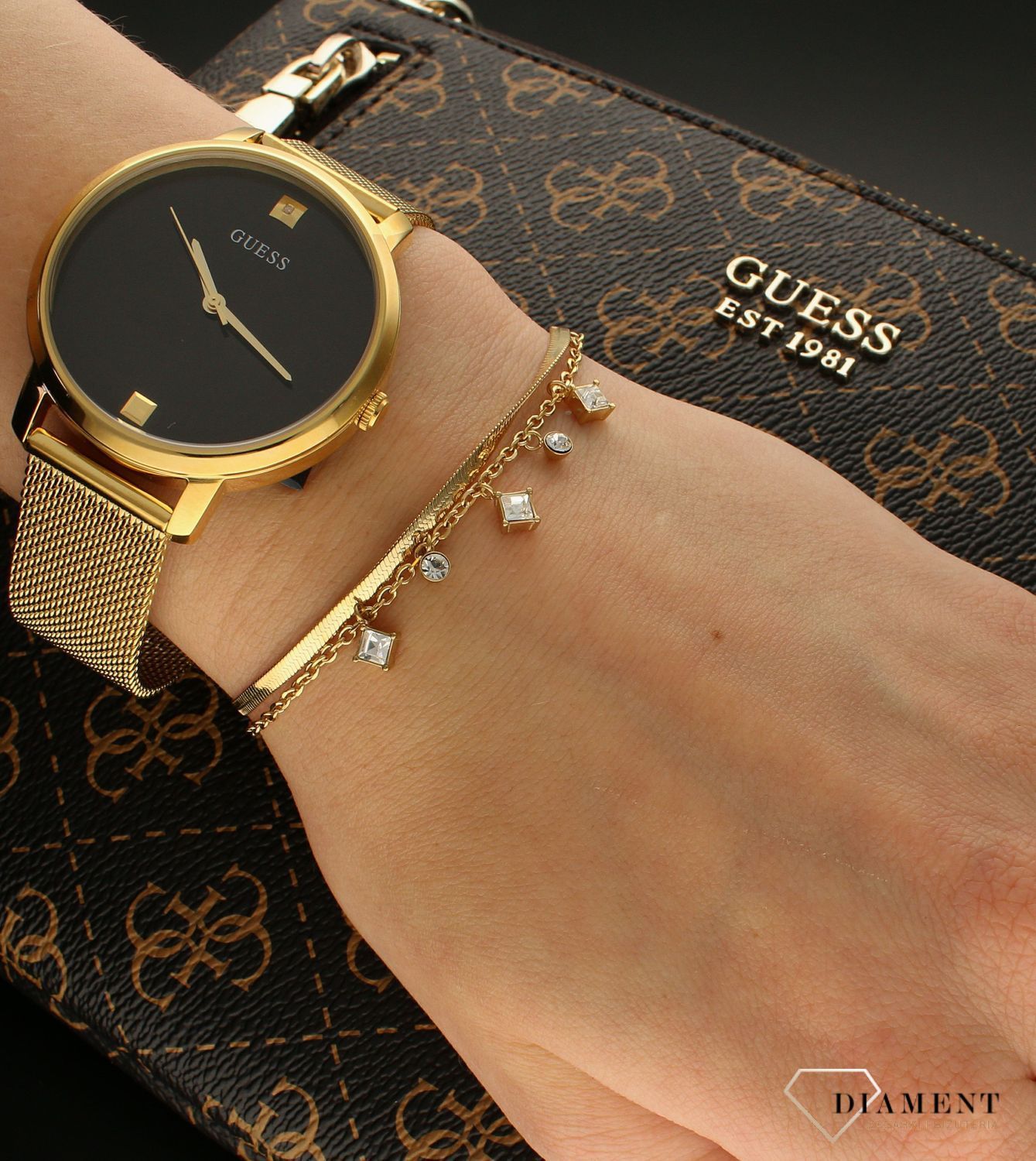 Bransoletka damska Guess z białymi cyrkoniami JUBB03068JWYGWHS. Bransoletka damska Guess w złotym kolorze z wiszącymi elementami ozdobnymi w białym kolorze. Stalowa bransoletka w kolorze złotym z cyrkoniami. Bransoletka Guess na prezent..jpg