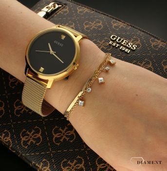 Bransoletka damska Guess z białymi cyrkoniami JUBB03068JWYGWHS. Bransoletka damska Guess w złotym kolorze z wiszącymi elementami ozdobnymi w białym kolorze. Stalowa bransoletka w kolorze złotym z cyrkonia (1).jpg