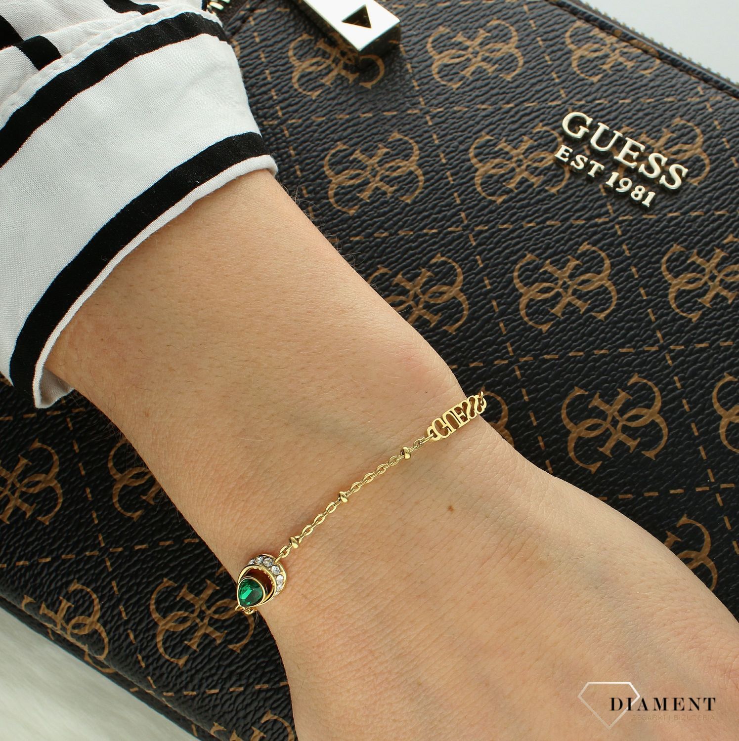 Bransoletka damska Guess z logo Guess i zieloną cyrkonią JUBB03399JWYGS. Bransoletka damska Guess. Bransoletka damska stalowa Guess. Bransoletka w złotym kolorze Guess. Bransoletka Guess damska z cyrkoniami..jpg