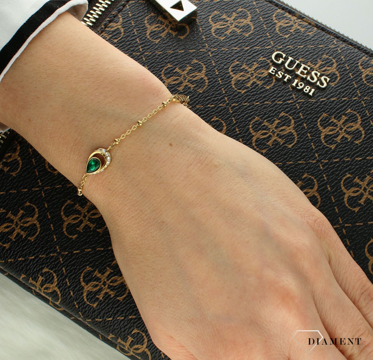 Bransoletka damska Guess z logo Guess i zieloną cyrkonią JUBB03399JWYGS. Bransoletka damska Guess. Bransoletka damska stalowa Guess. Bransoletka w złotym kolorze Guess. Bransoletka Guess damska z cyrkoniami..jpg
