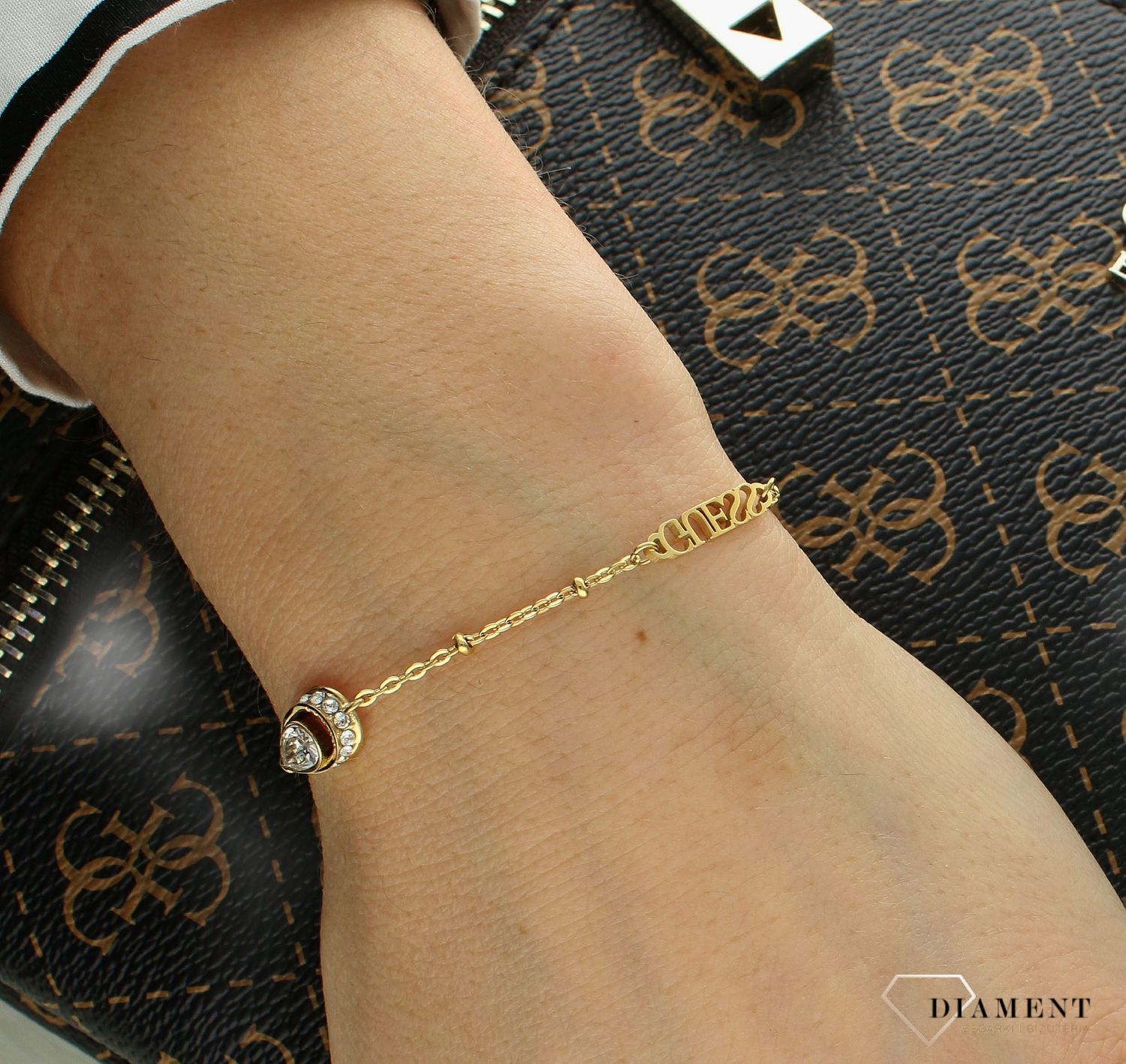 Bransoletka damska Guess z logo Guess i białą cyrkonią JUBB03392JWYGS.  Bransoletka damska Guess. Bransoletka damska stalowa Guess. Bransoletka w złotym kolorze Guess. Bransoletka Guess damska z cyrkoniami..jpg
