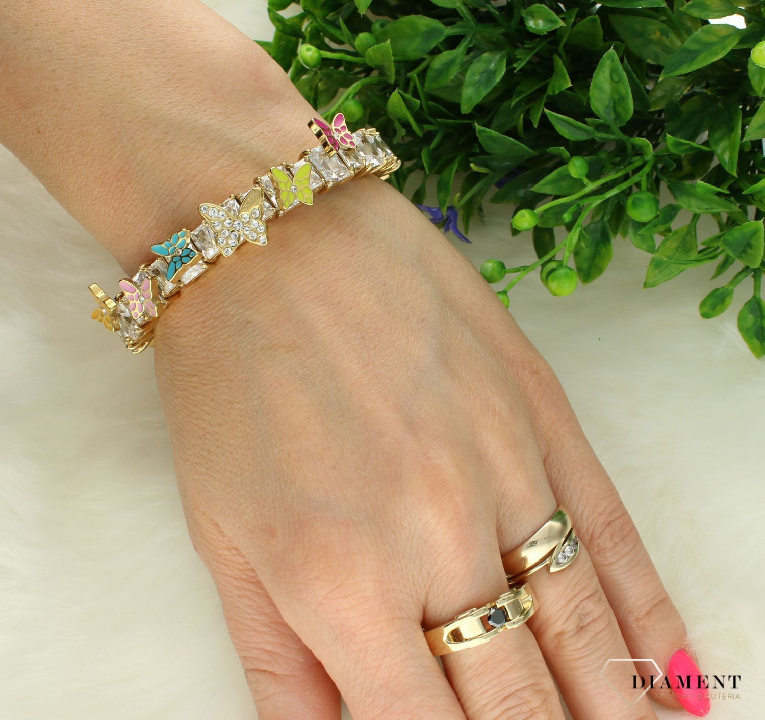 Bransoletka GUESS stalowa w kolorze złotym z cyrkoniami i kolorowymi motylkami JUBB04088JWYGMCTU. Stalowa bransoletka Guess. Bransoletrka damska w złotym kolorze Guess. Modna bransoletka damska Guess z cyrkoniami. Bransoletka damska Guess na pr.jpg