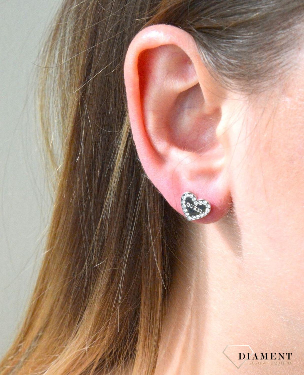 Nausznica srebrna GUESS z łańcuszkiem i kolczykami  JUBE01080JWRHTU. Nausznica w kolorze srebra GUESS z łańcuszkiem i kolczykami w kształcie serca. Stalowe kolczyki z motywem serca ozdobione błyszczącymi kryształami.jpg