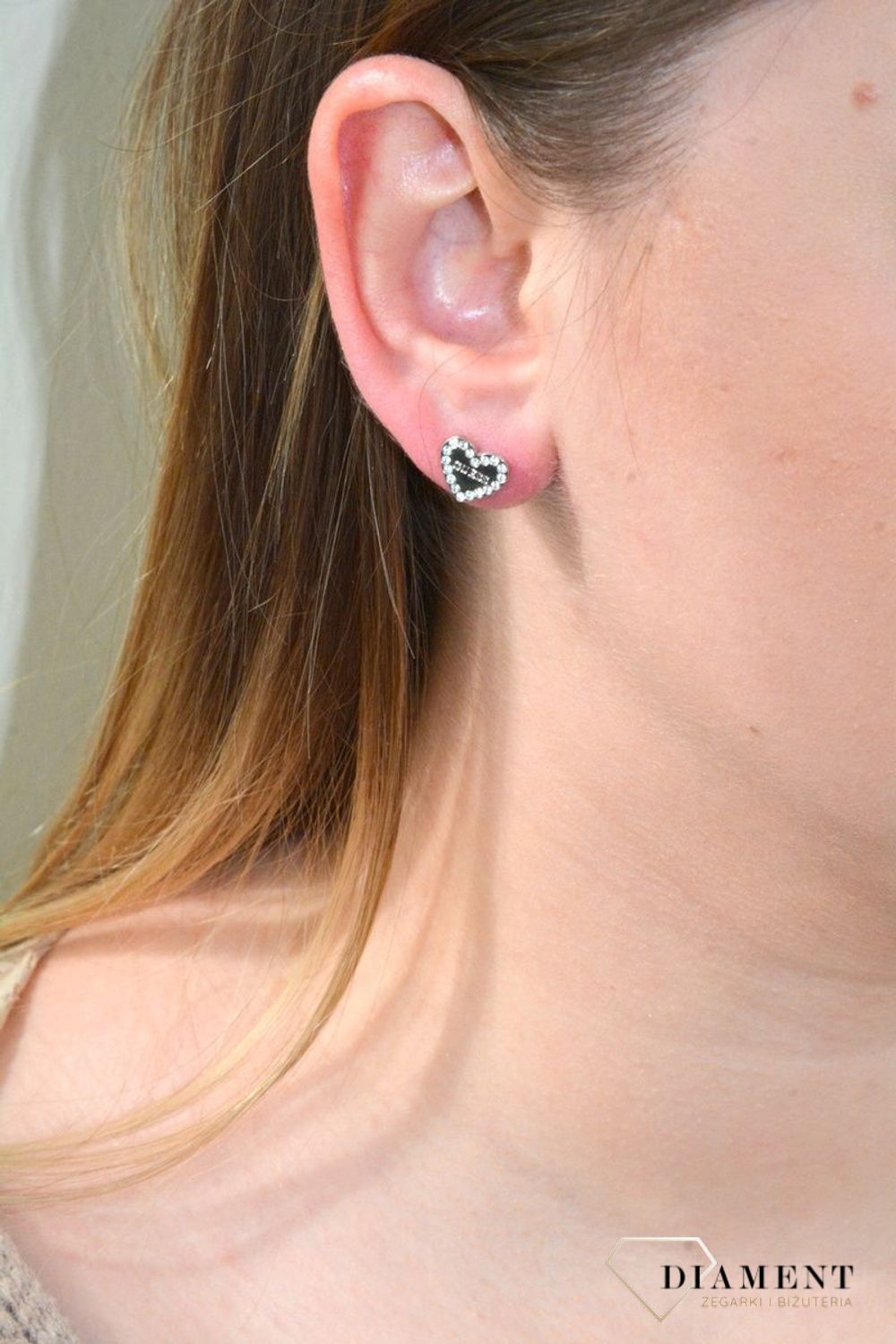 Nausznica srebrna GUESS z łańcuszkiem i kolczykami  JUBE01080JWRHTU. Nausznica w kolorze srebra GUESS z łańcuszkiem i kolczykami w kształcie serca. Stalowe kolczyki z motywem serca ozdobione błyszczącymi kryształami.jpg