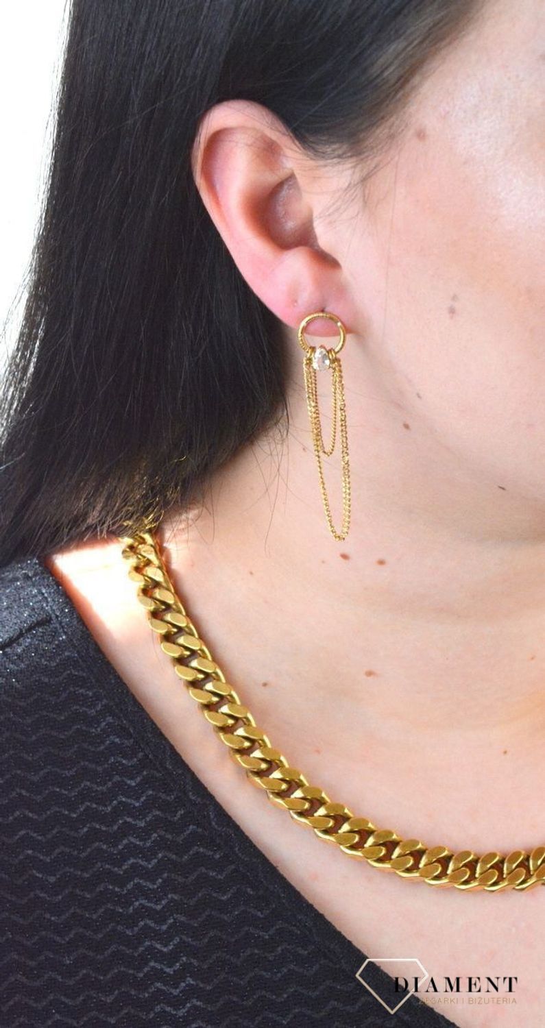 Stalowe kolczyki wiszące z logo marki GUESS w kolorze złotym. Kolczyki składają się z łańcuszków pancerki do którego dołączony jest kryształka..jpg