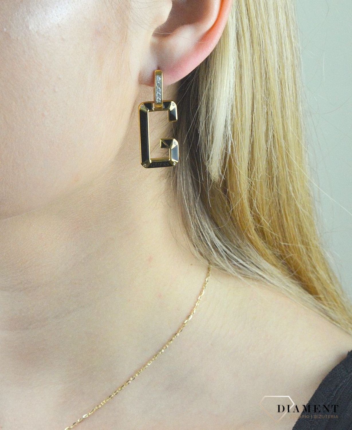 Kolczyki GUESS stalowe pozłacane literka 'G' w kolorze czarnym JUBE01469JWYGBK. Stalowe kolczyki  wiszące z logo marki 'G' w kolorze czarnym ozdobiony kryształami. Kolczyki składają się z zapięcia do którego dołączone logo w (1).jpg