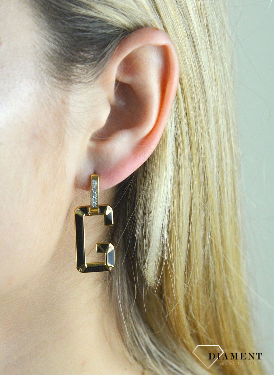 Kolczyki GUESS stalowe pozłacane literka 'G' w kolorze czarnym JUBE01469JWYGBK. Stalowe kolczyki  wiszące z logo marki 'G' w kolorze czarnym ozdobiony kryształami. Kolczyki składają się z zapięcia do którego dołączone logo w (1).jpg