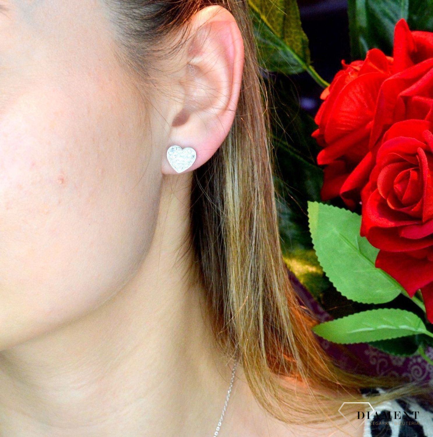 Kolczyki damskie GUESS stalowe serca z cyrkoniami JUBE02173JWRHT.  Kolczyki GUESS stalowe z napisem Guess i cyrkoniami w kształcie subtelnych serduszek. Stalowe kolczyki  wykonane z najwyższej jakości stali w kolorze srebra ozdobione kryszta.webp