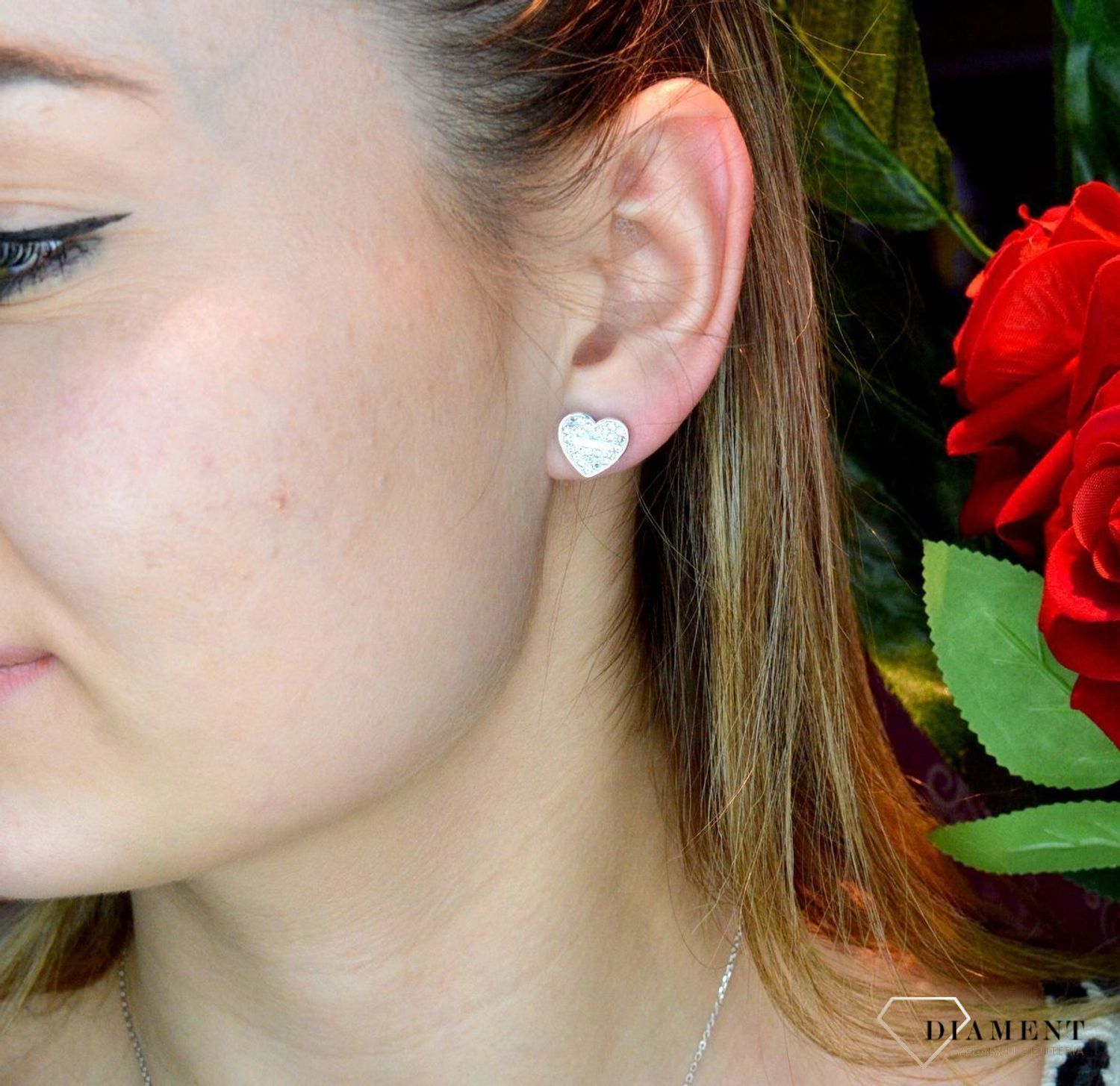 Kolczyki damskie GUESS stalowe serca z cyrkoniami JUBE02173JWRHT.  Kolczyki GUESS stalowe z napisem Guess i cyrkoniami w kształcie subtelnych serduszek. Stalowe kolczyki  wykonane z najwyższej jakości stali w kolorze srebra ozdobione kryszta.webp