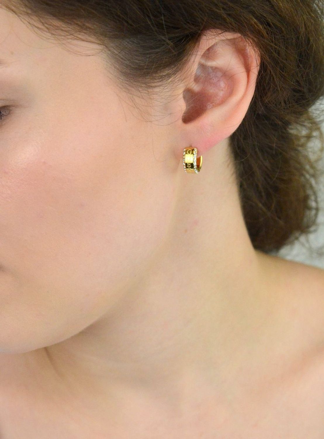 Eleganckie kolczyki Guess JUBE03112JWYGTU – pozłacane stalowe kółeczka z cyrkoniami i napisem Guess. Styl i blask w jednym. Sprawdź online!1.jpg