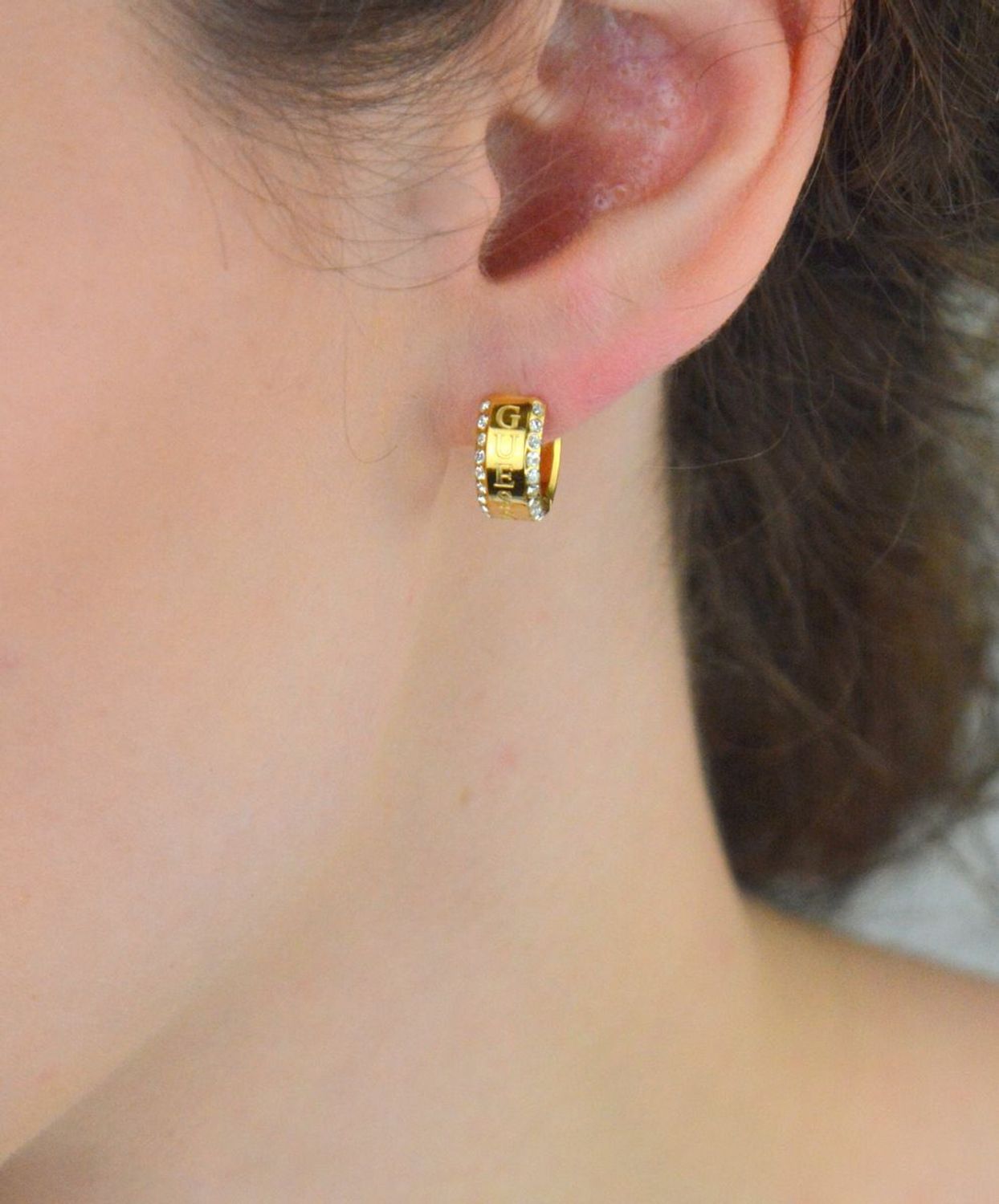 Eleganckie kolczyki Guess JUBE03112JWYGTU – pozłacane stalowe kółeczka z cyrkoniami i napisem Guess. Styl i blask w jednym. Sprawdź online!1.jpg