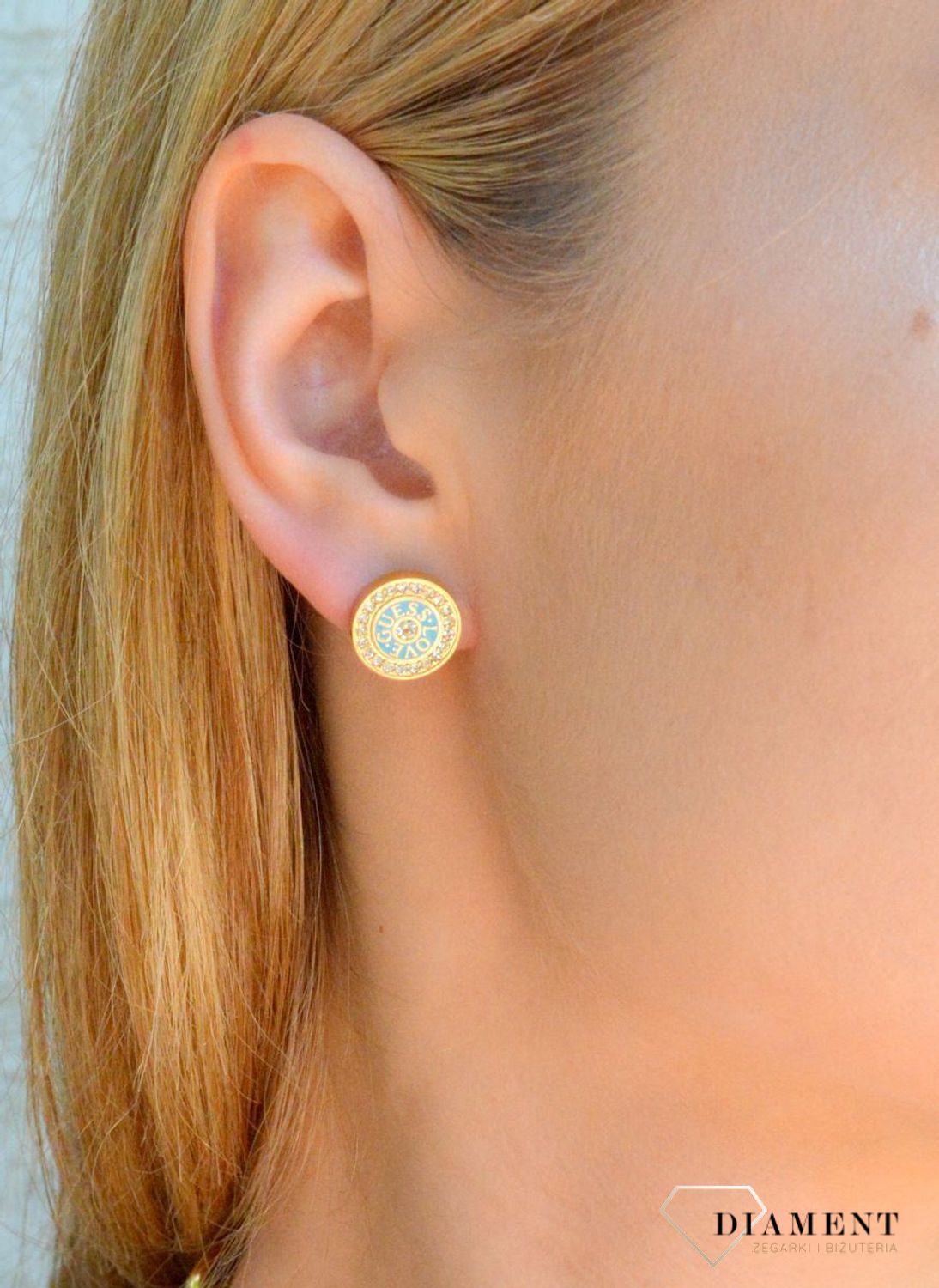 Złote kolczyki wkrętki Guess z niebieską emalią i cyrkoniami JUBE04081JWYGTQT-U. Stalowe koczyki marki Guess. Kolczyki stalowe z cyrkoniami. Kolczyki z cyrkoniami Guess. Kolczyki Guess na sztyft idealne na prezent..jpg