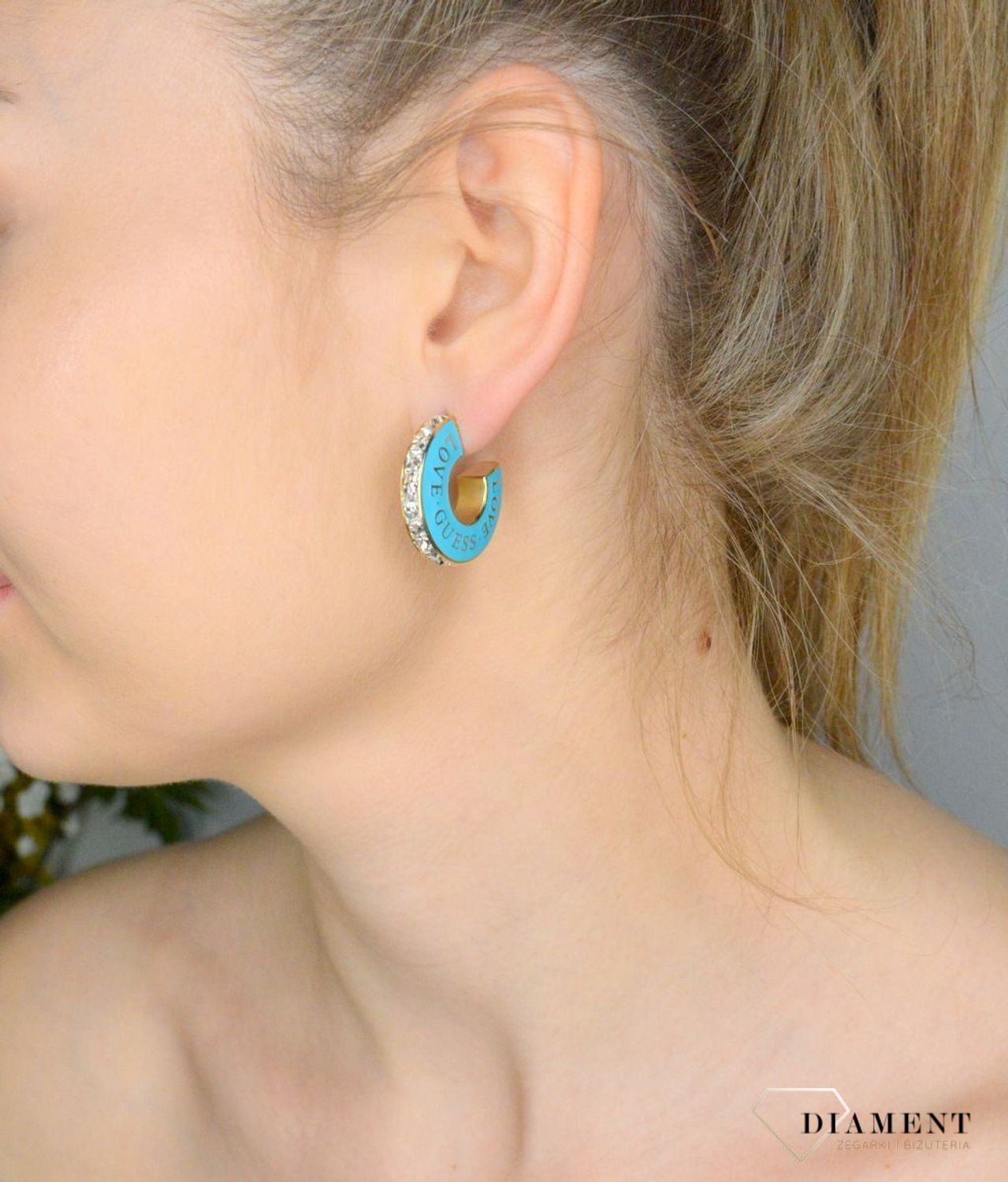Kolczyki GUESS z emalią w kolorze turkusowym JUBE04083JWYGTQT-U. Kolczyki wykonane ze stali w kolorze złotym z emalią w kolorze turkusowym z logo marki GUESS (1).jpg